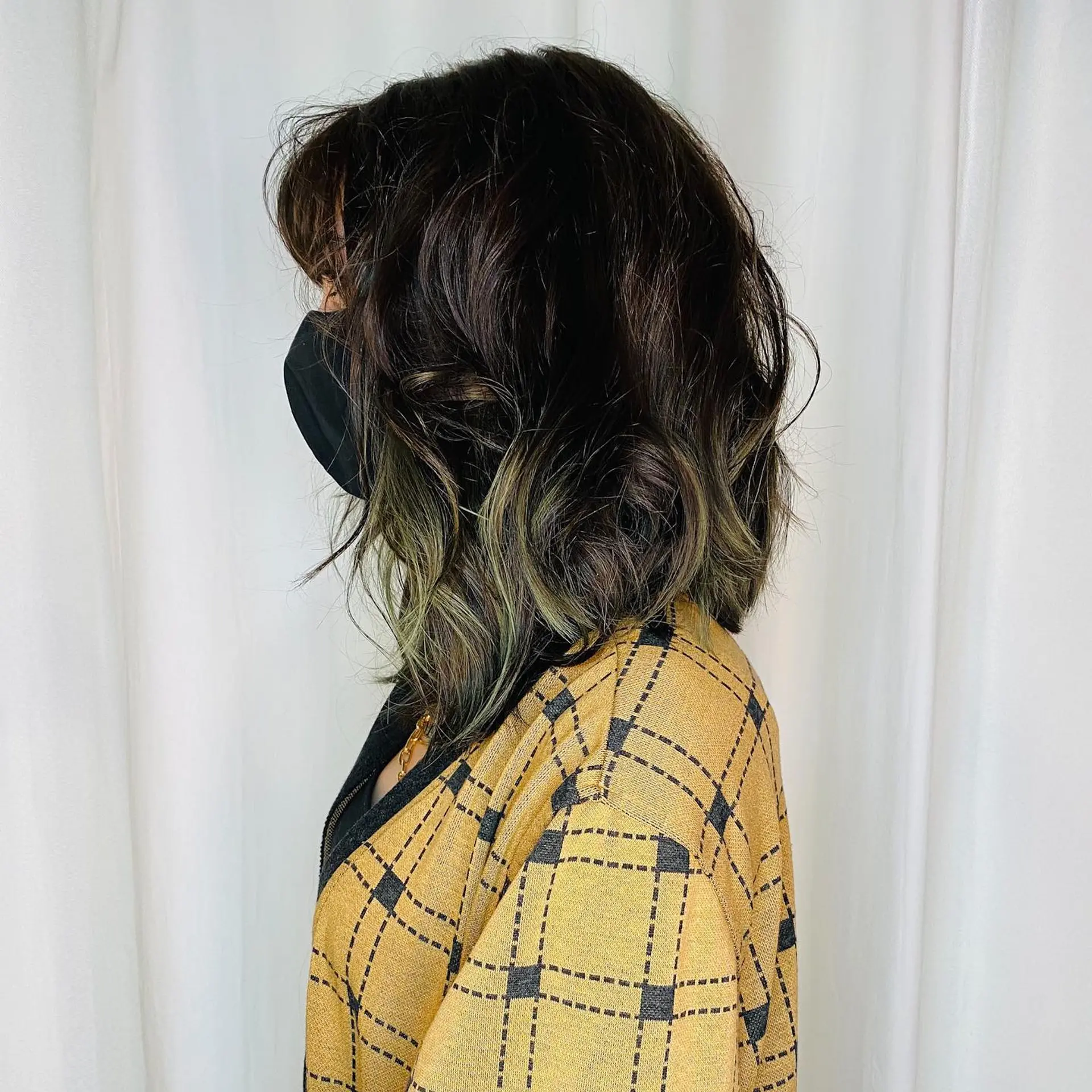 A medium-length wavy lob featuring a deep dark brown shadow root that seamlessly blends into striking moss green ends. 1