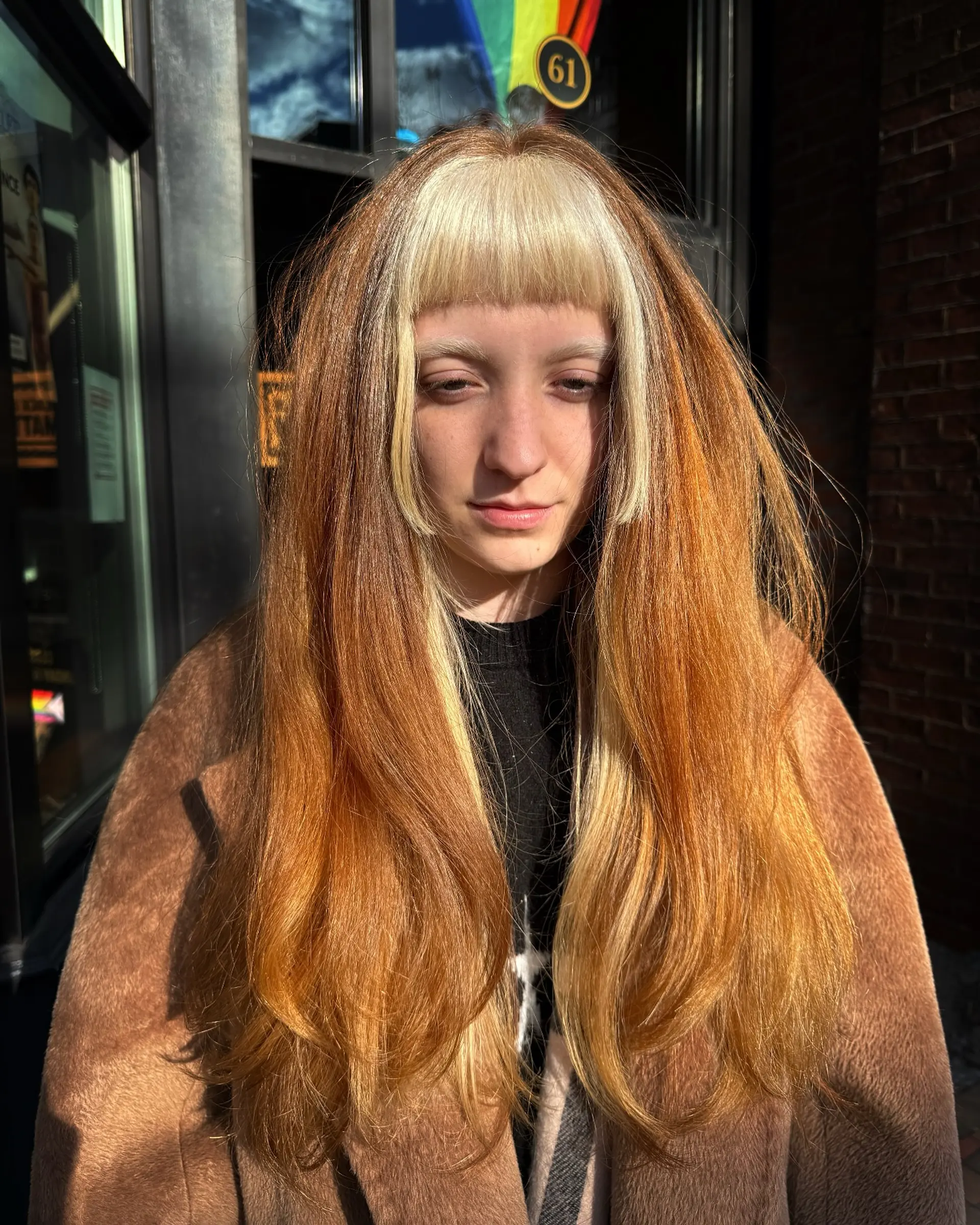 Long warm copper hair styled with high-contrast, bleached platinum blonde blunt bangs and face-framing side pieces. 1