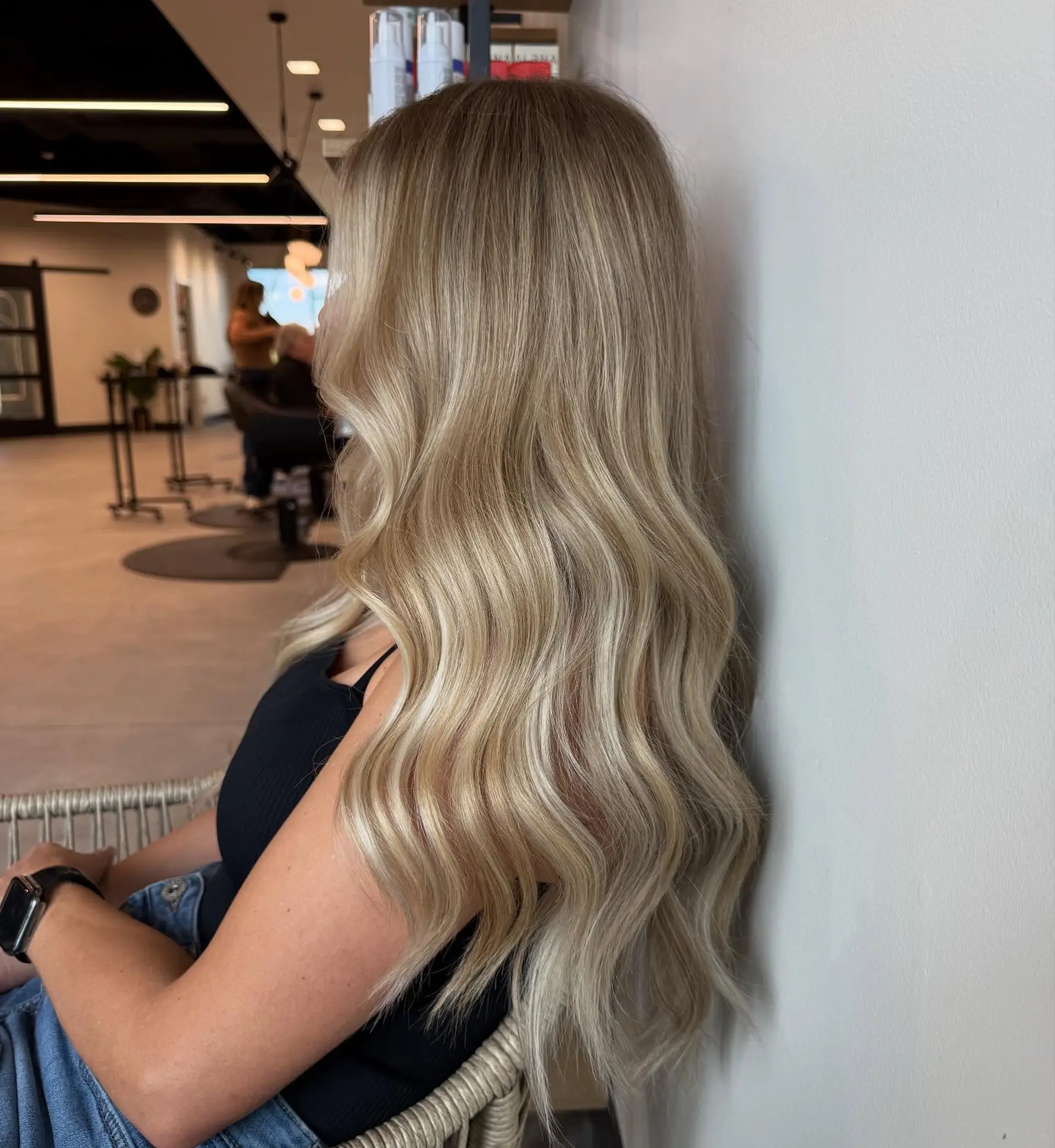 Long dimensional blonde hair styled with soft, glamorous waves and a high-shine finish. 1