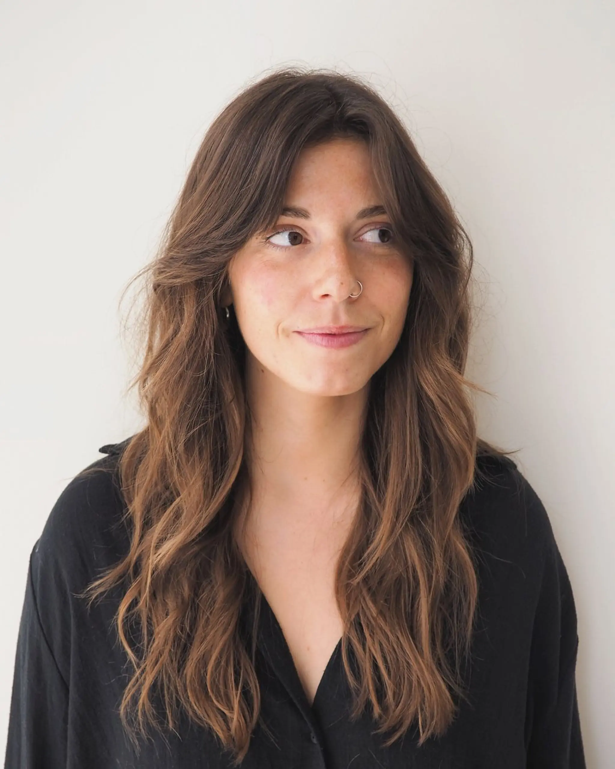 Long, chestnut brown waves with face-framing layers and subtle, natural texture for an effortless, relaxed look.