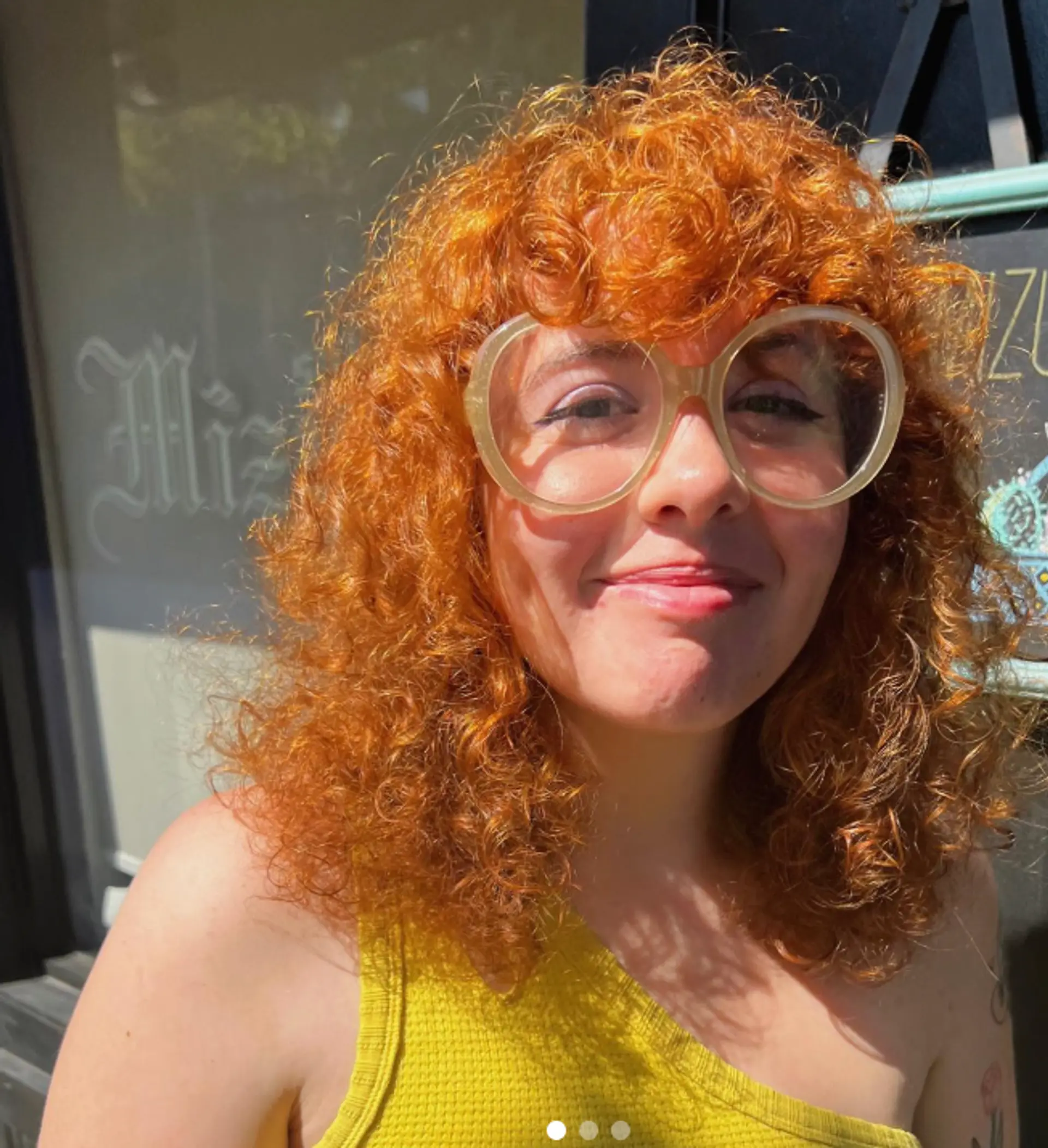 A medium-length curly hairstyle with fringe bangs. 1