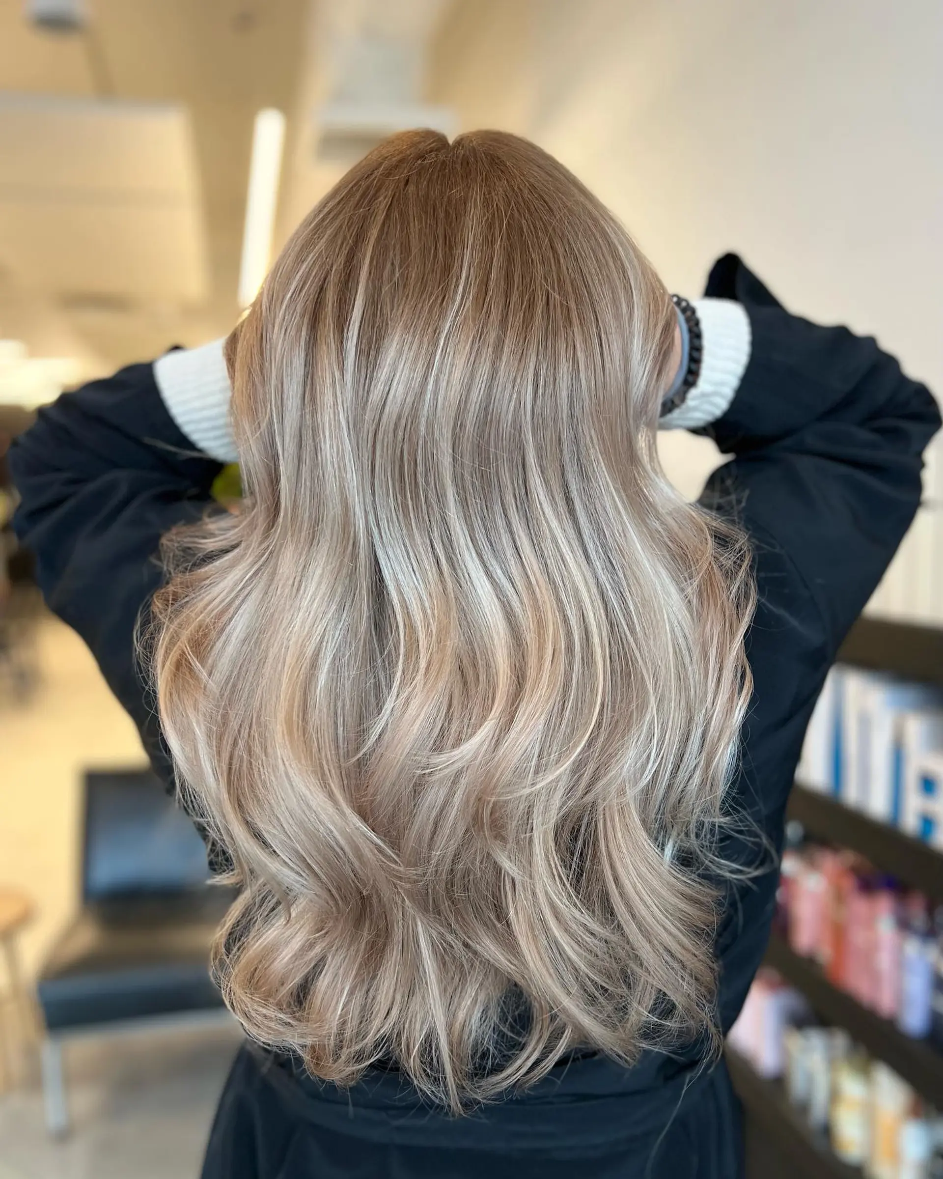 Long beige blonde hair with a blended root melt, dimensional highlights, and flowing soft waves. 1