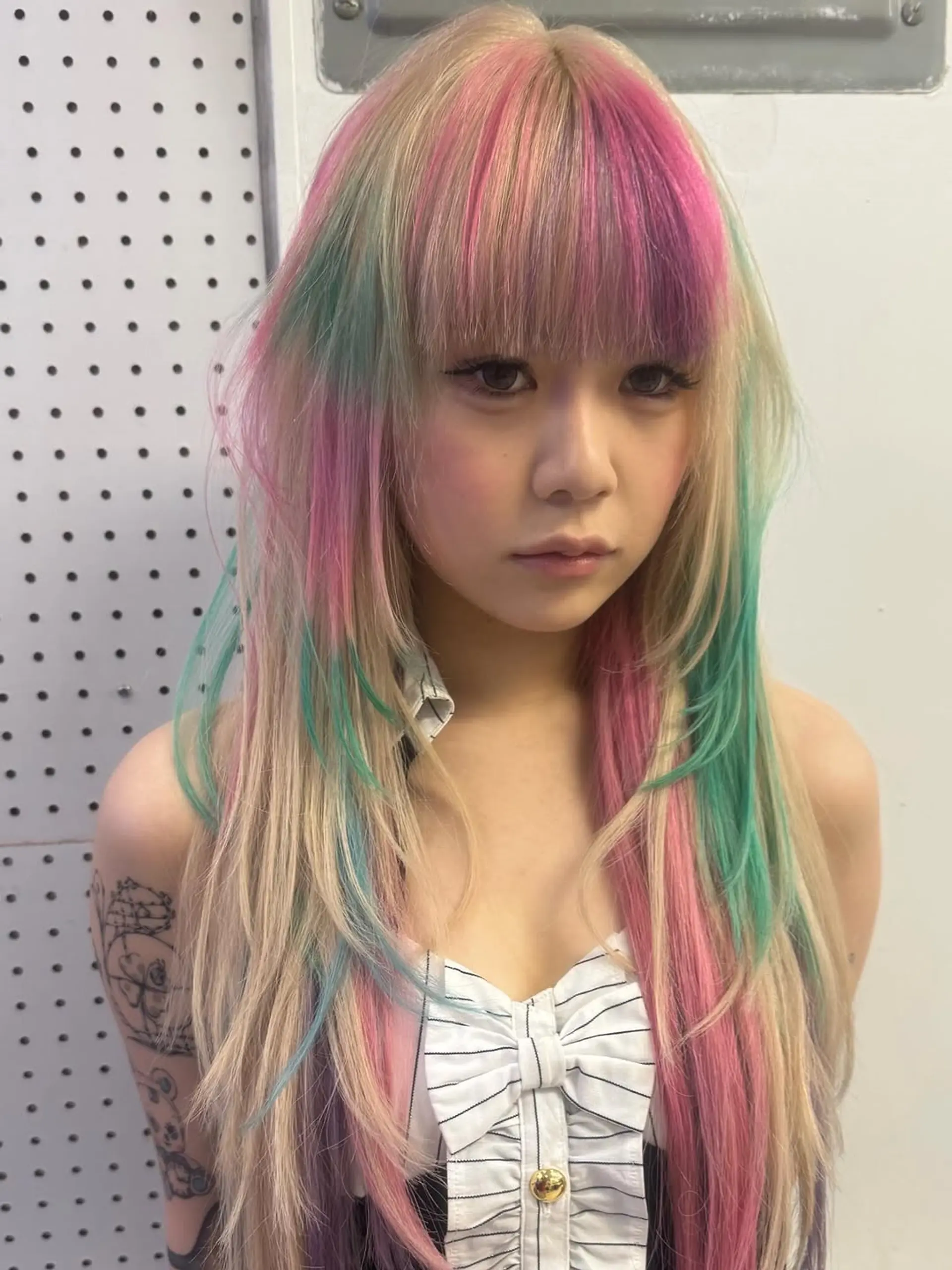 A long, layered shag haircut with wispy bangs, featuring vibrant pastel pink and mint green color blocking on a platinum blonde base. 1