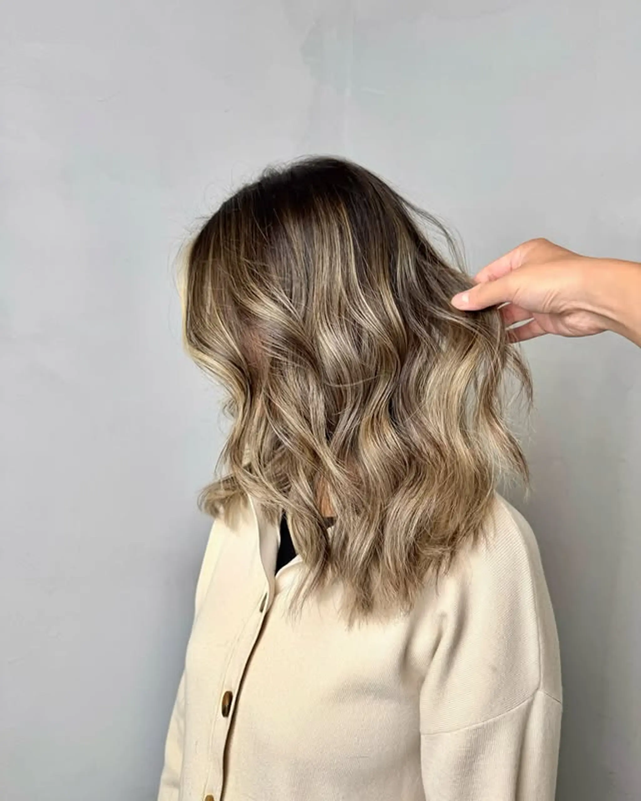 A trendy medium-length lob with bronde balayage and effortless beach waves.