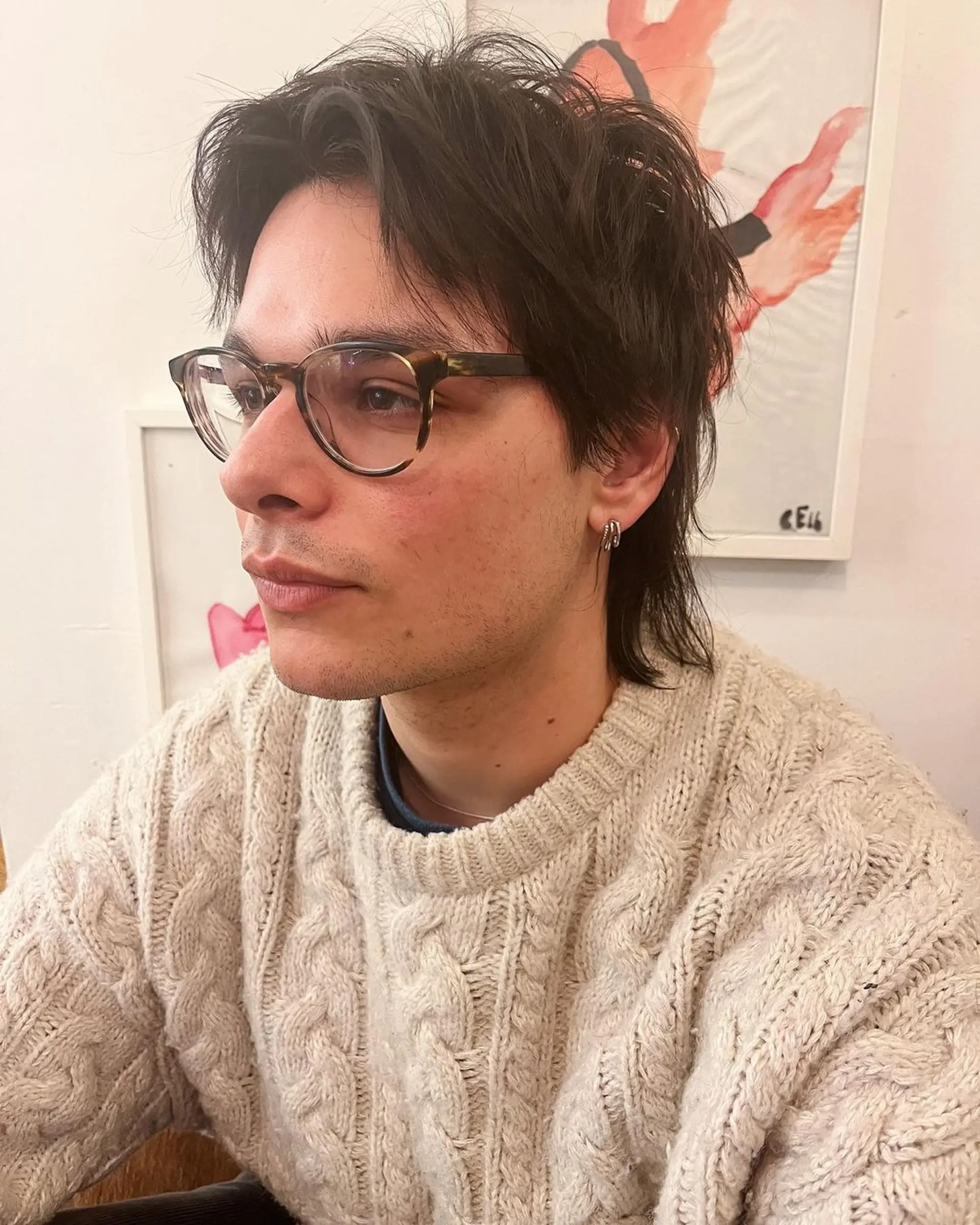 This look features a relaxed, medium length, layered cut for an adult male with straight, dark brown hair. The style includes a side-swept fringe and light texturing, creating a natural, casually sophisticated appearance. 1