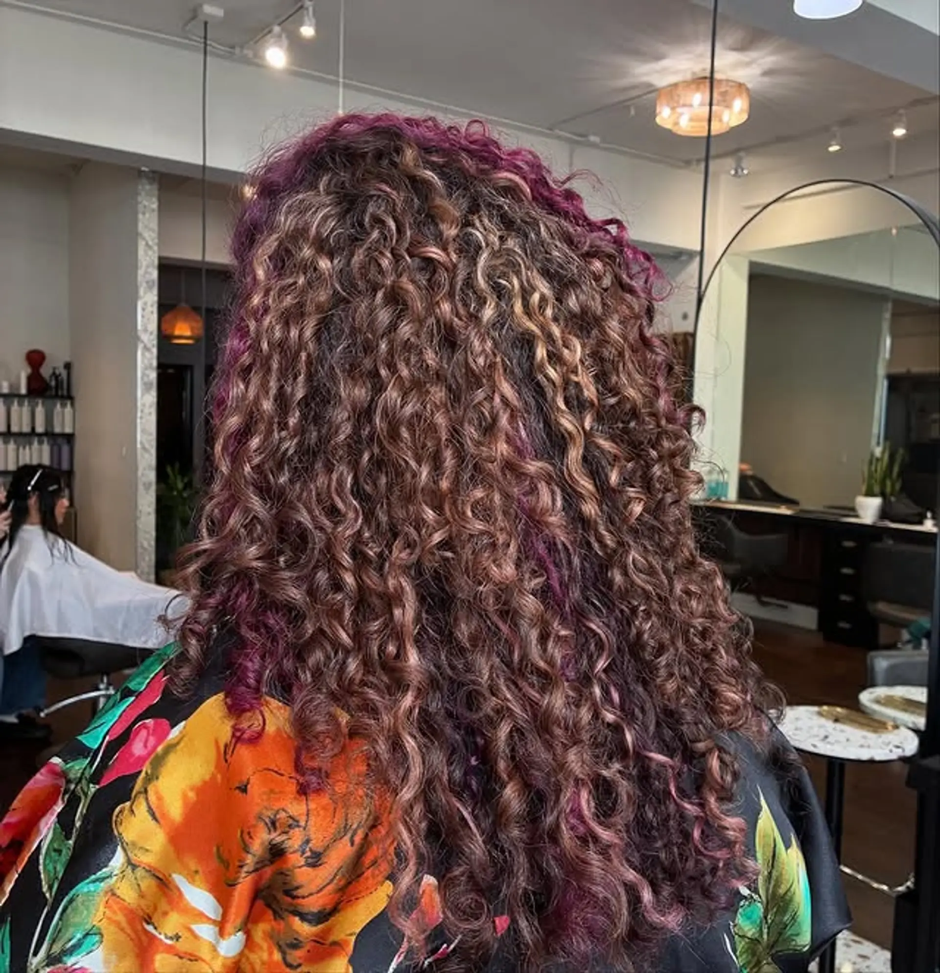 Long, dimensional curly hair with magenta highlights. 1