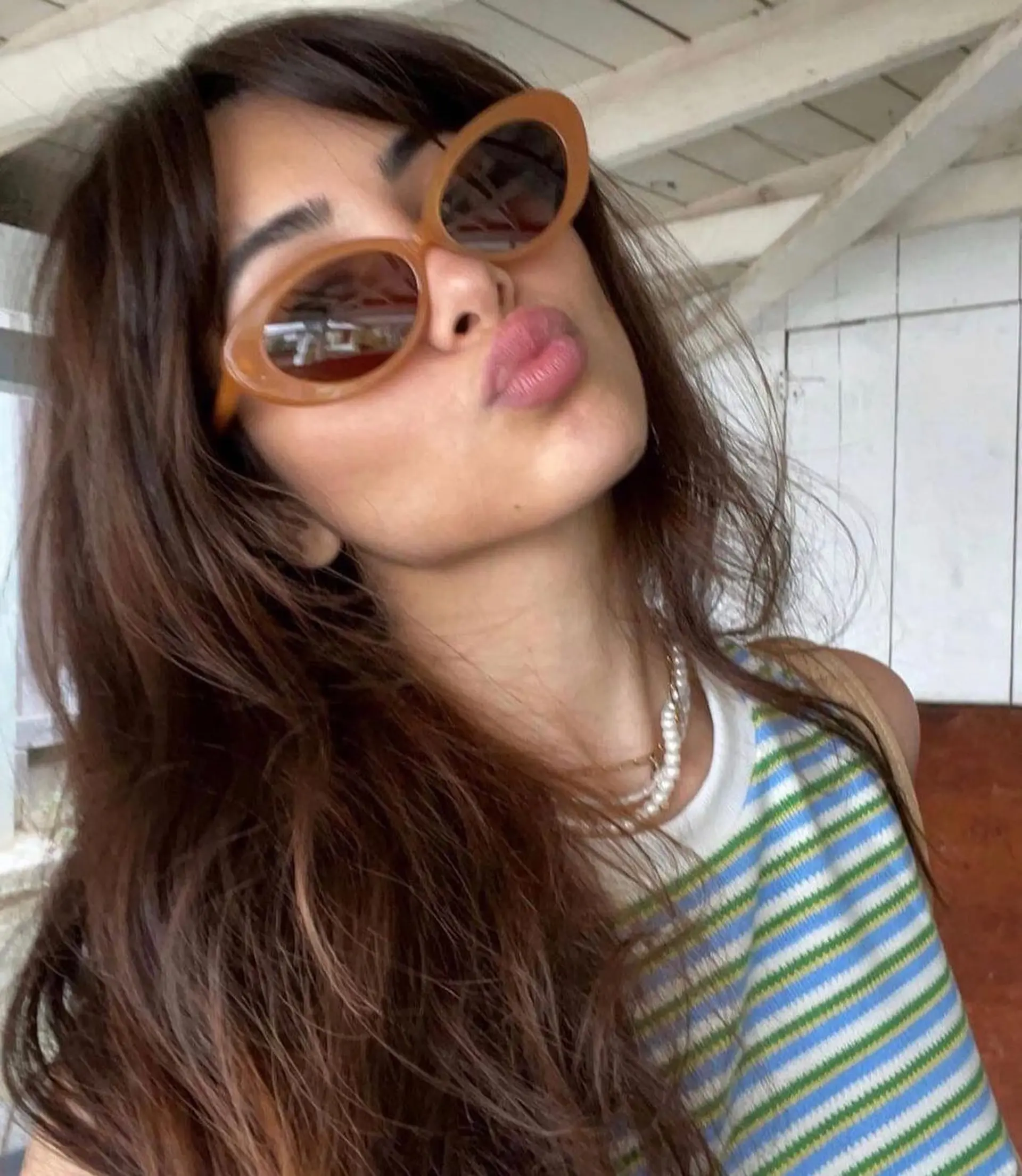 Long rich brown hair styled with soft, tousled waves and face-framing curtain bangs. 1