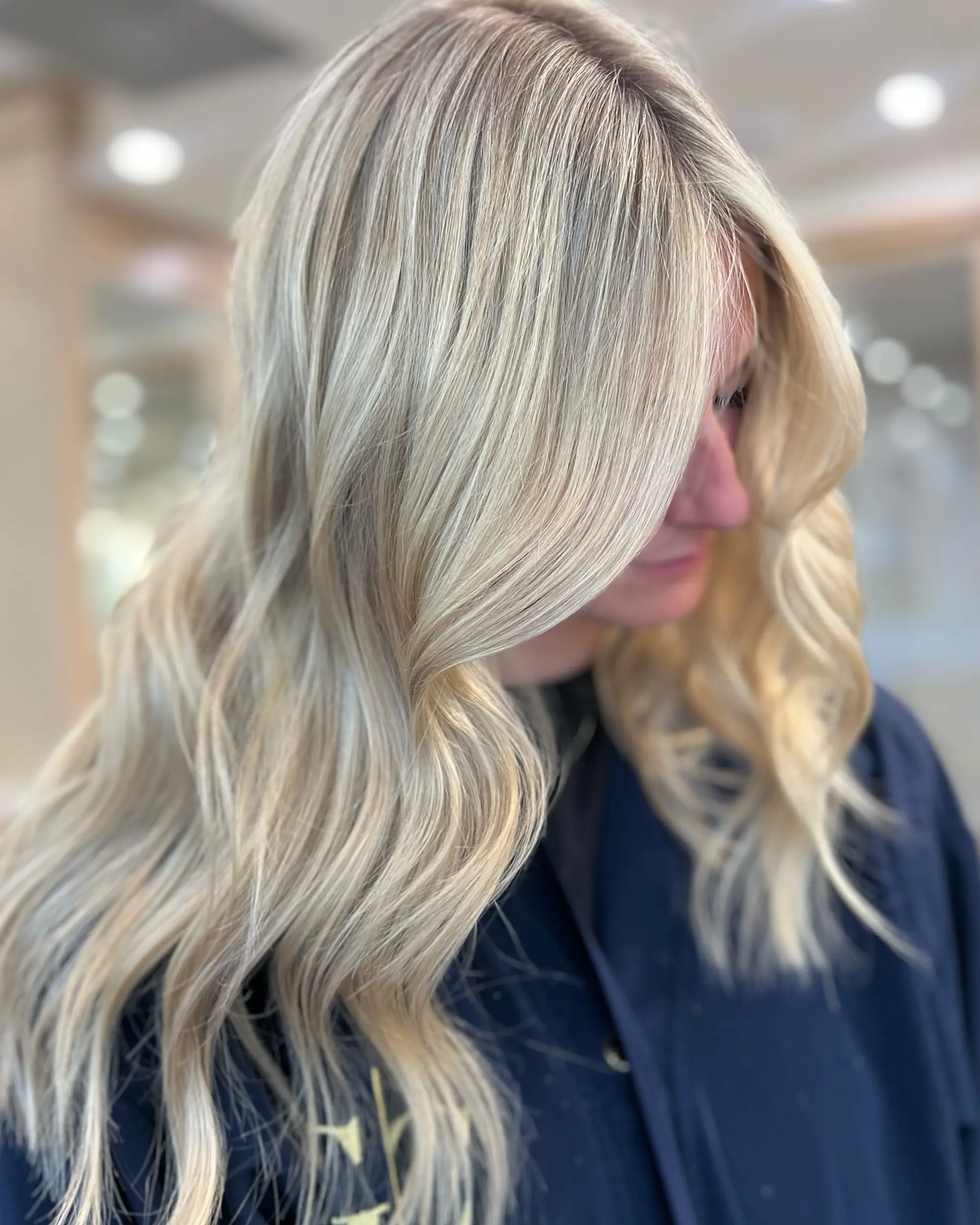 This hairstyle features long, platinum blonde hair styled into soft, beachy waves. 1