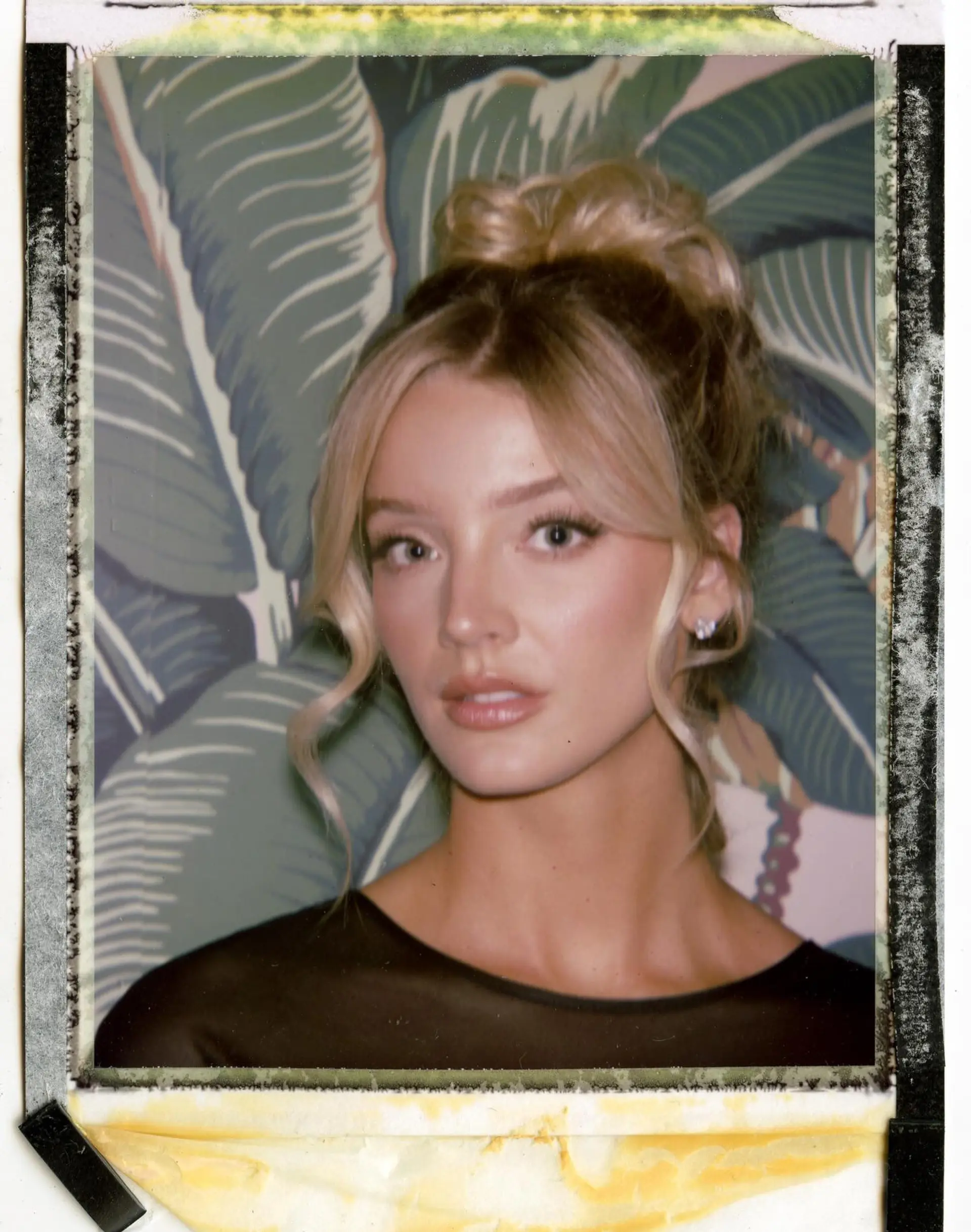 A glamorous high bun updo featuring soft, wavy face-framing tendrils parted in the center. 1