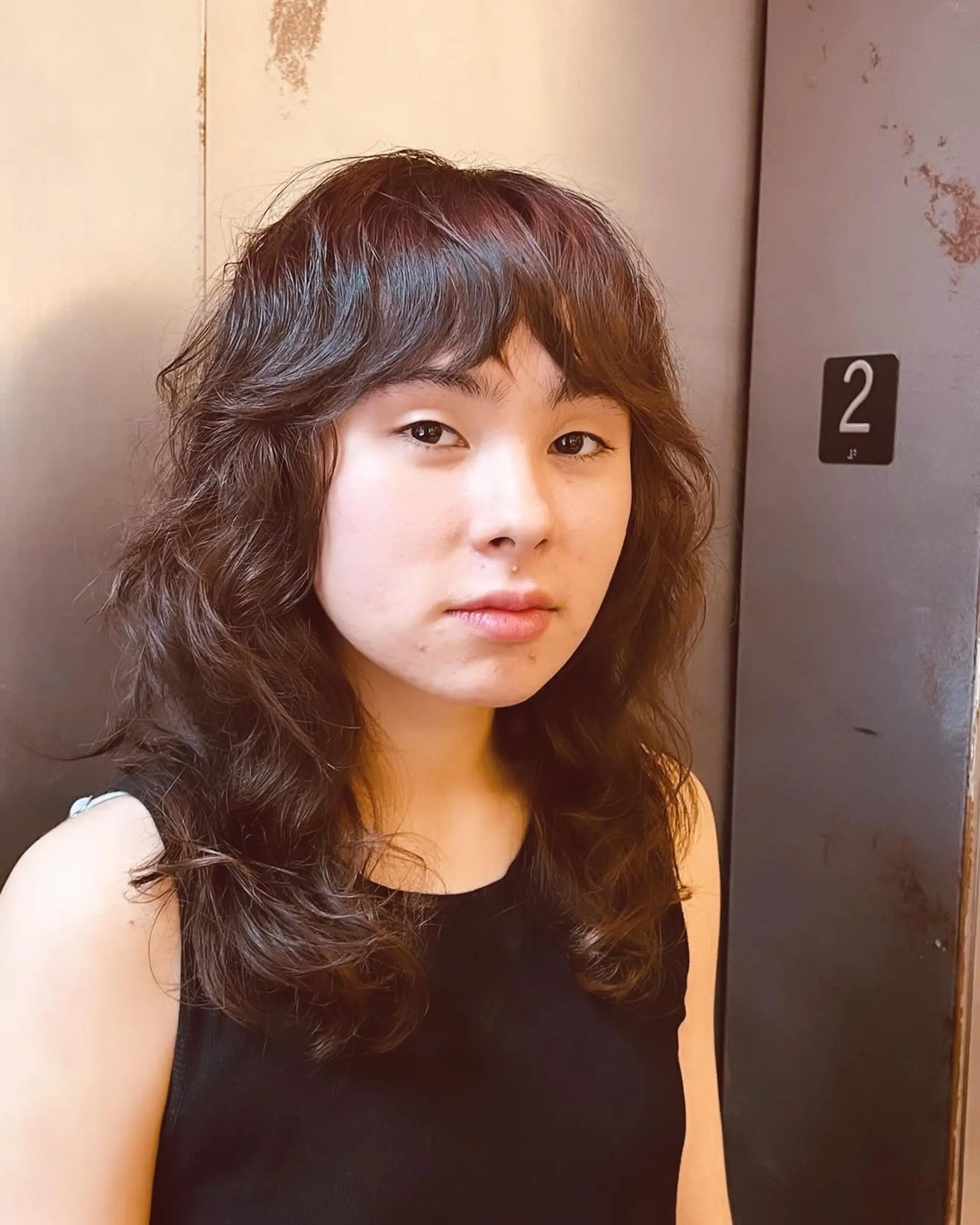 Medium-length wavy hair with soft fringe bangs and layered waves. 1