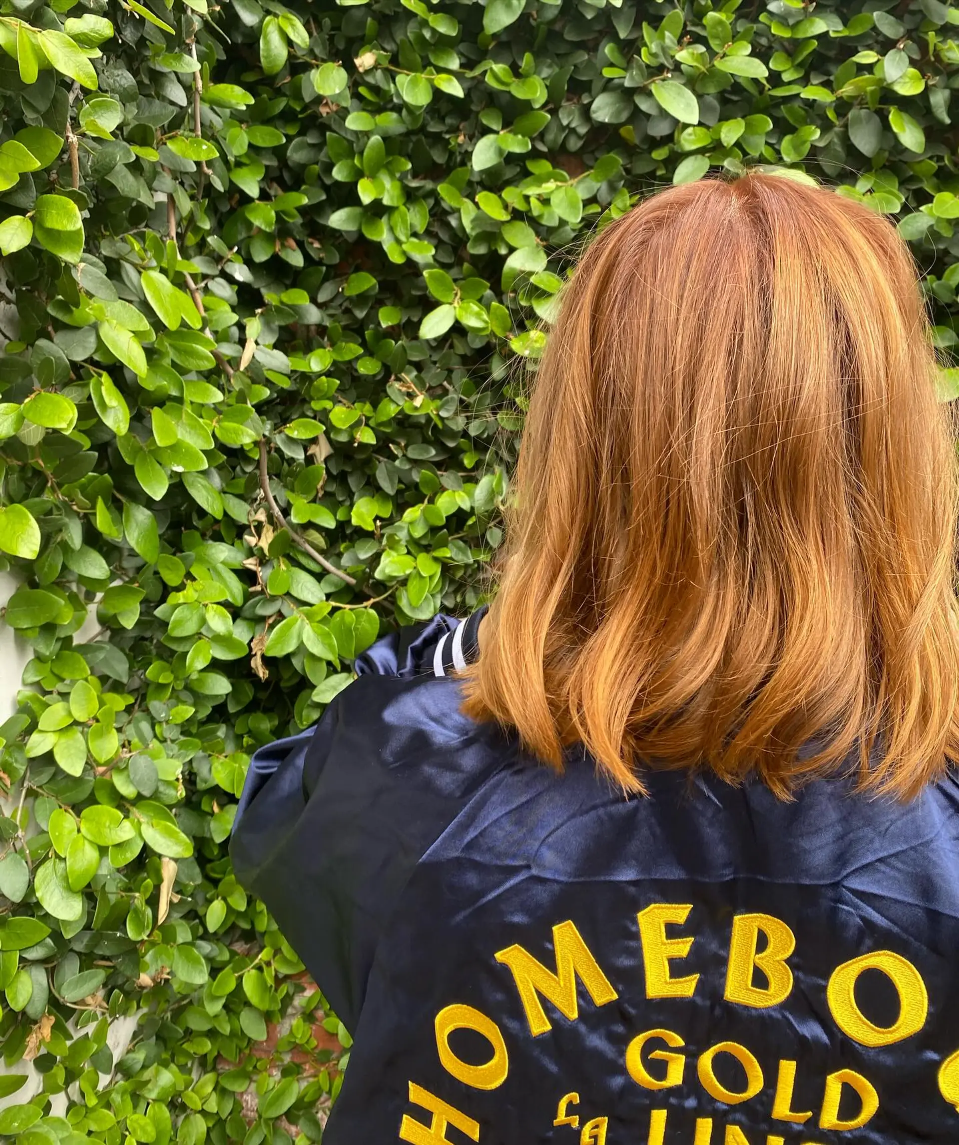 A back-facing view of a shoulder-length haircut in a vibrant warm copper hair color. 1