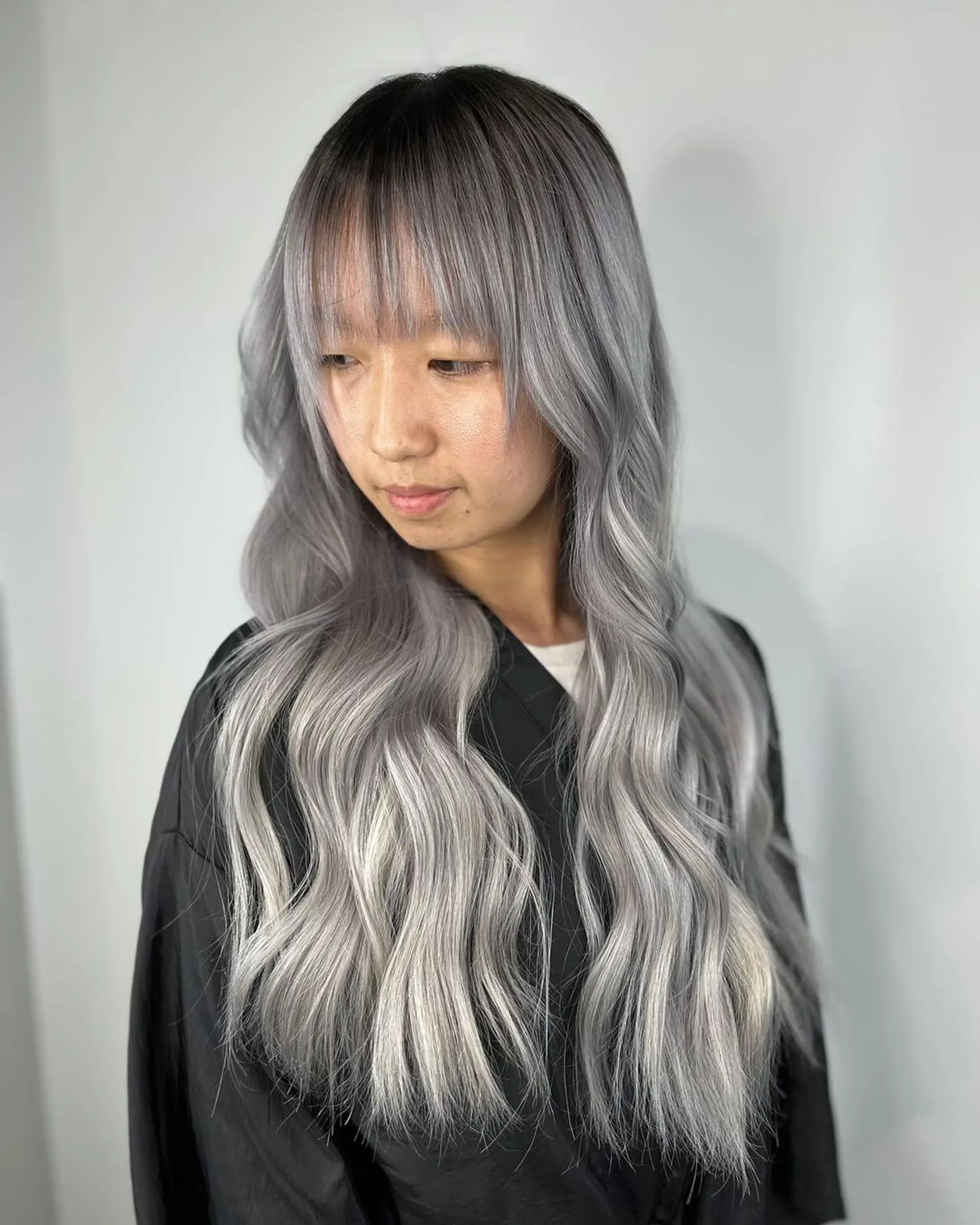 A very long wavy hairstyle with an ombre transition from platinum to silver, featuring face-framing bangs and layered ends.
Stylist - @xcellent_jason 1