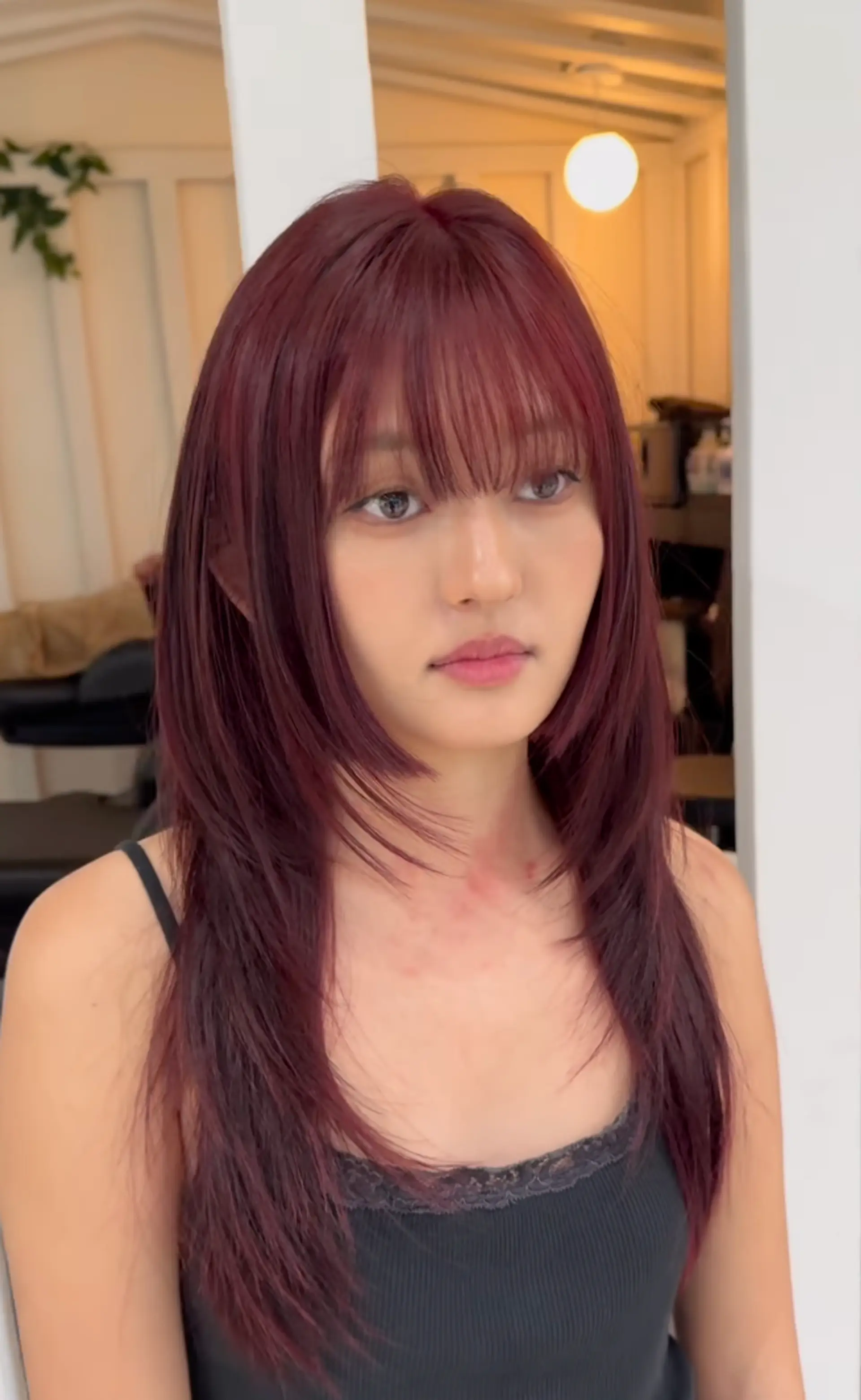 Long, straight hair in burgundy and maroon, with side-swept layers, a full fringe, and a glossy finish. 2