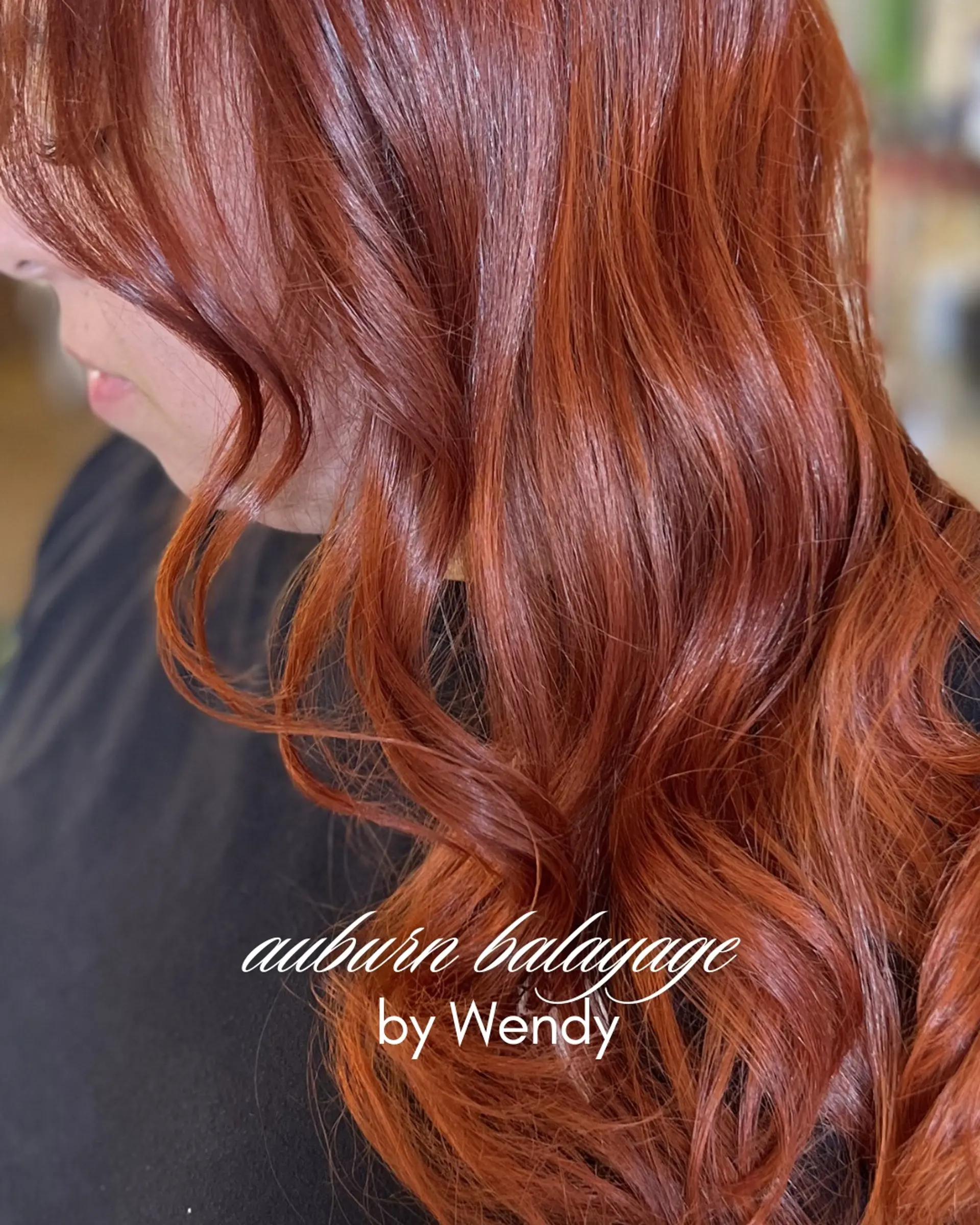 Rich auburn and copper dimensional balayage styled in loose, glossy waves. 1