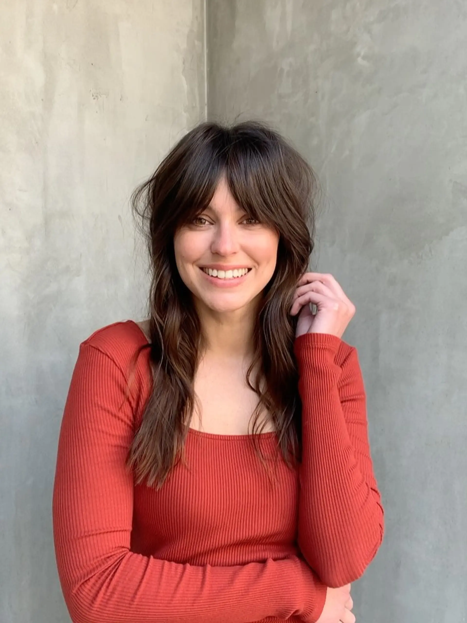 Medium-length dark brown shag haircut featuring soft, face-framing curtain bangs and textured layers. 1