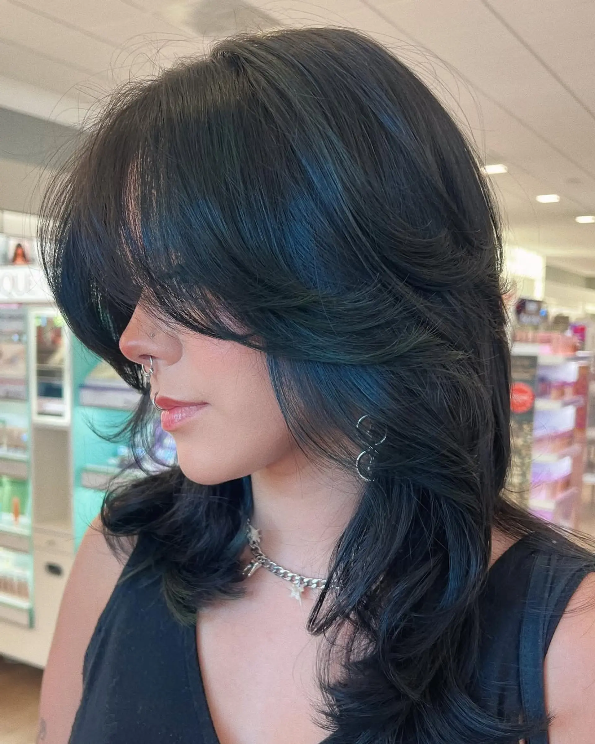 A trendy medium-length layered haircut featuring dramatic face-framing layers and soft waves, creating a modern wolf cut or shag aesthetic. This style offers volume and movement with a effortlessly cool vibe. 1