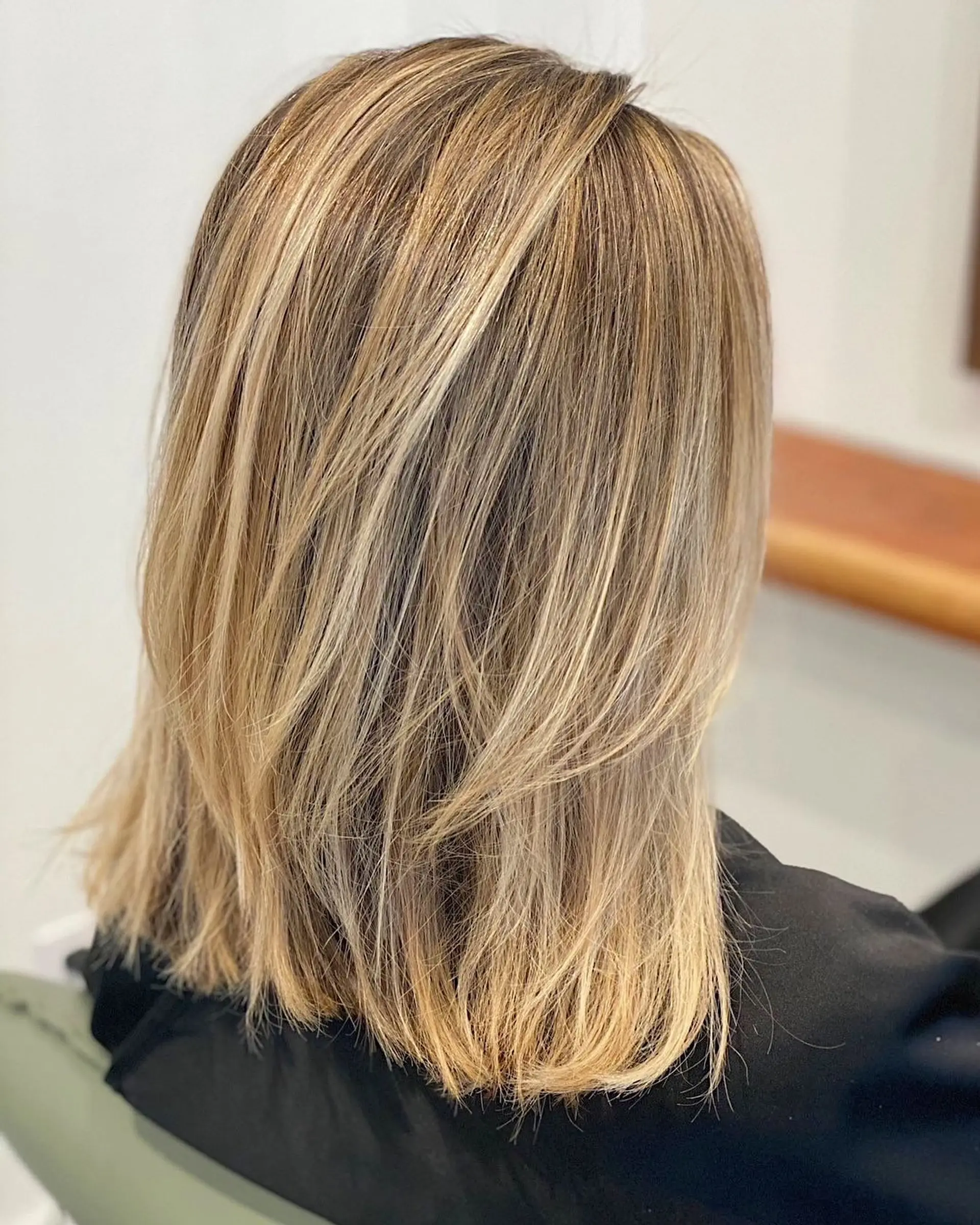 A layered lob with face-framing layers and bronde balayage highlights. 1