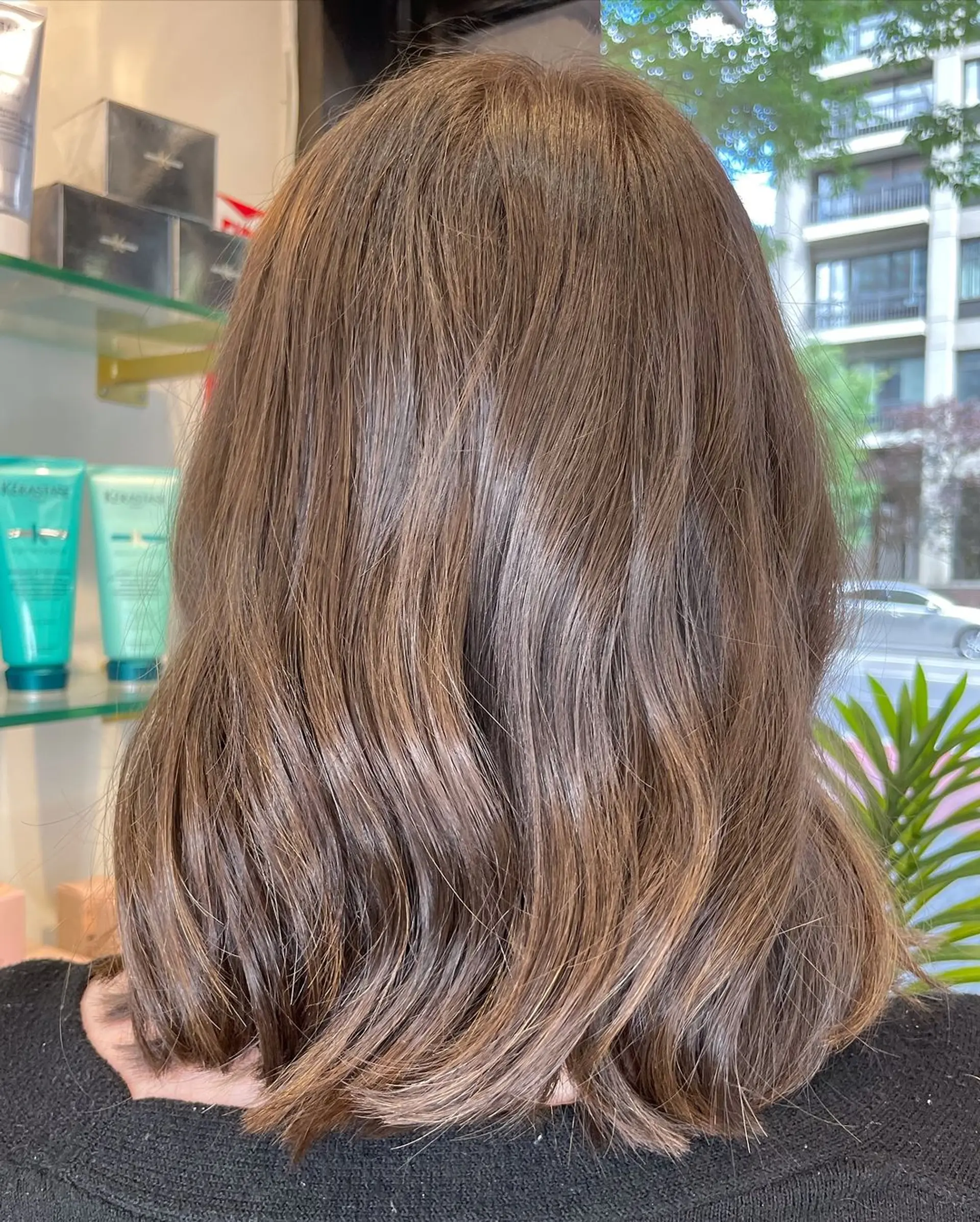 Beautiful, wavy light brown hair cascading to a medium length, just resting on the shoulders. The waves are soft and natural, giving a relaxed but polished appearance. 1