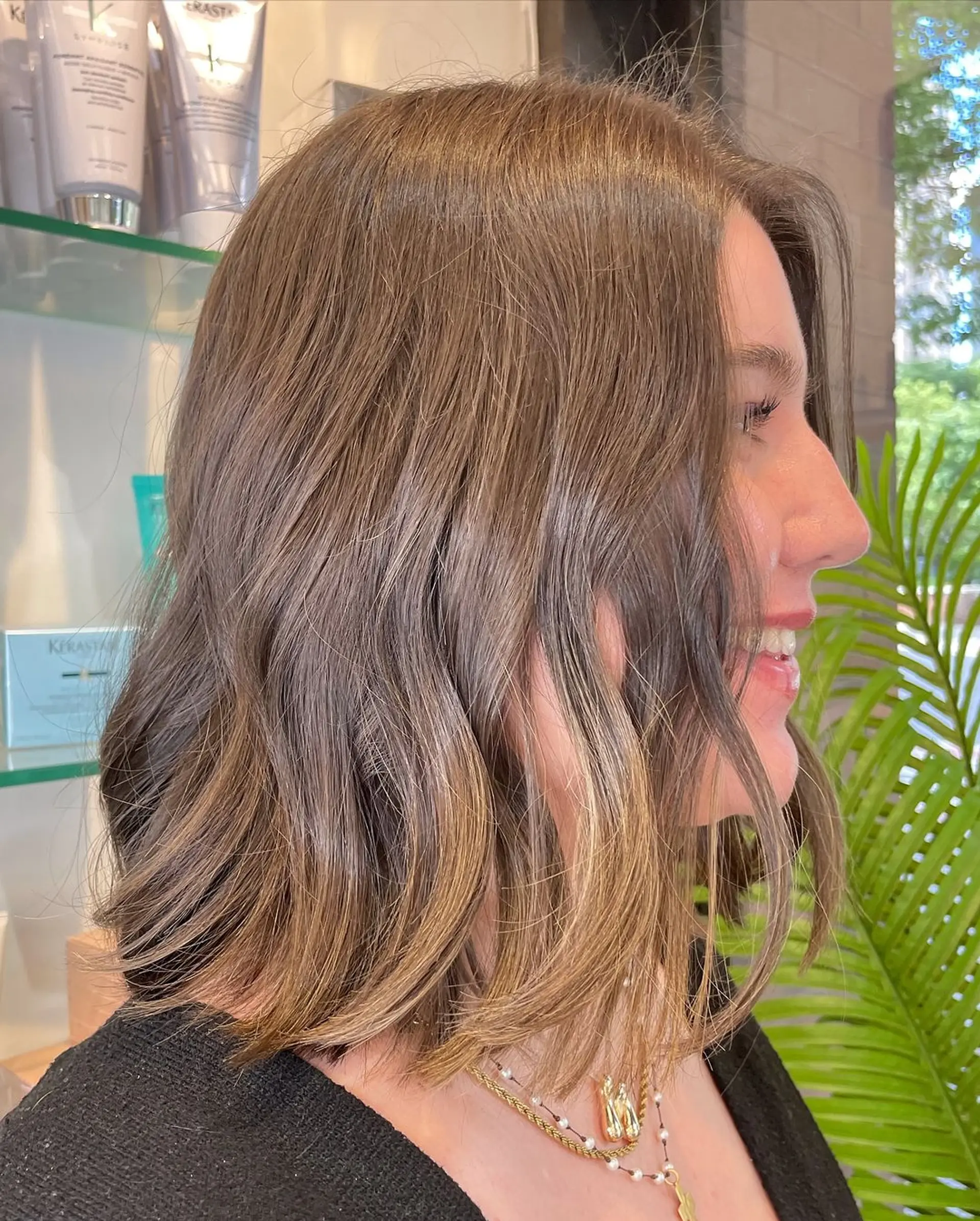 Beautiful, wavy light brown hair cascading to a medium length, just resting on the shoulders. The waves are soft and natural, giving a relaxed but polished appearance. 2