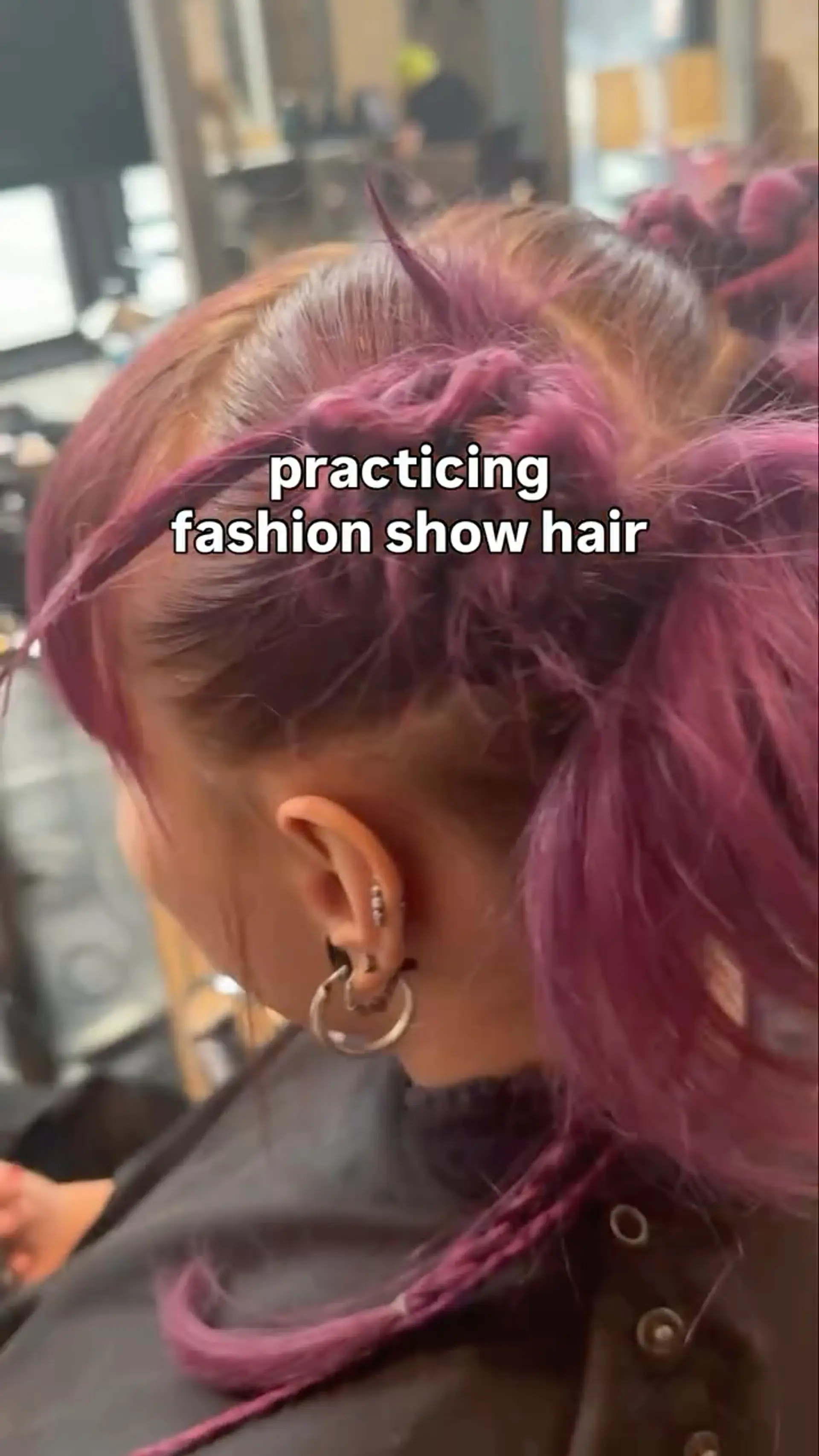 A high-fashion runway updo featuring textured magenta buns, woven micro-braids, and spiky accent strands. 1