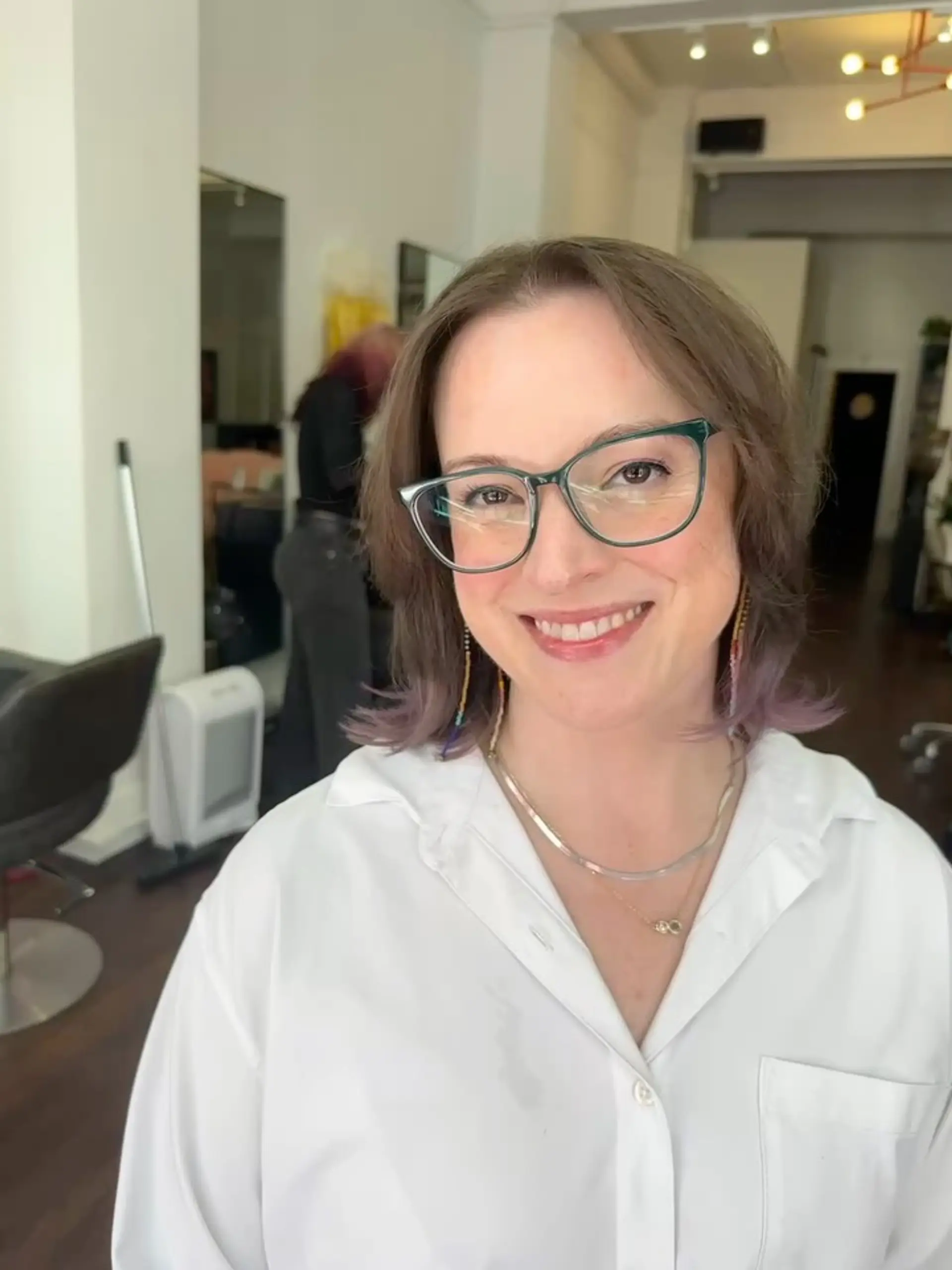 Shoulder-length layered cut with flipped-out ends and subtle pastel lavender tips. 1