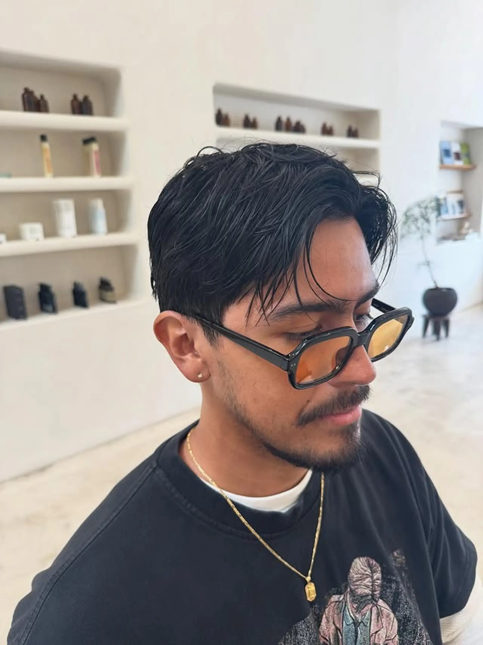 A short, tapered haircut with a wet look, perfect for a clean and stylish appearance. 1