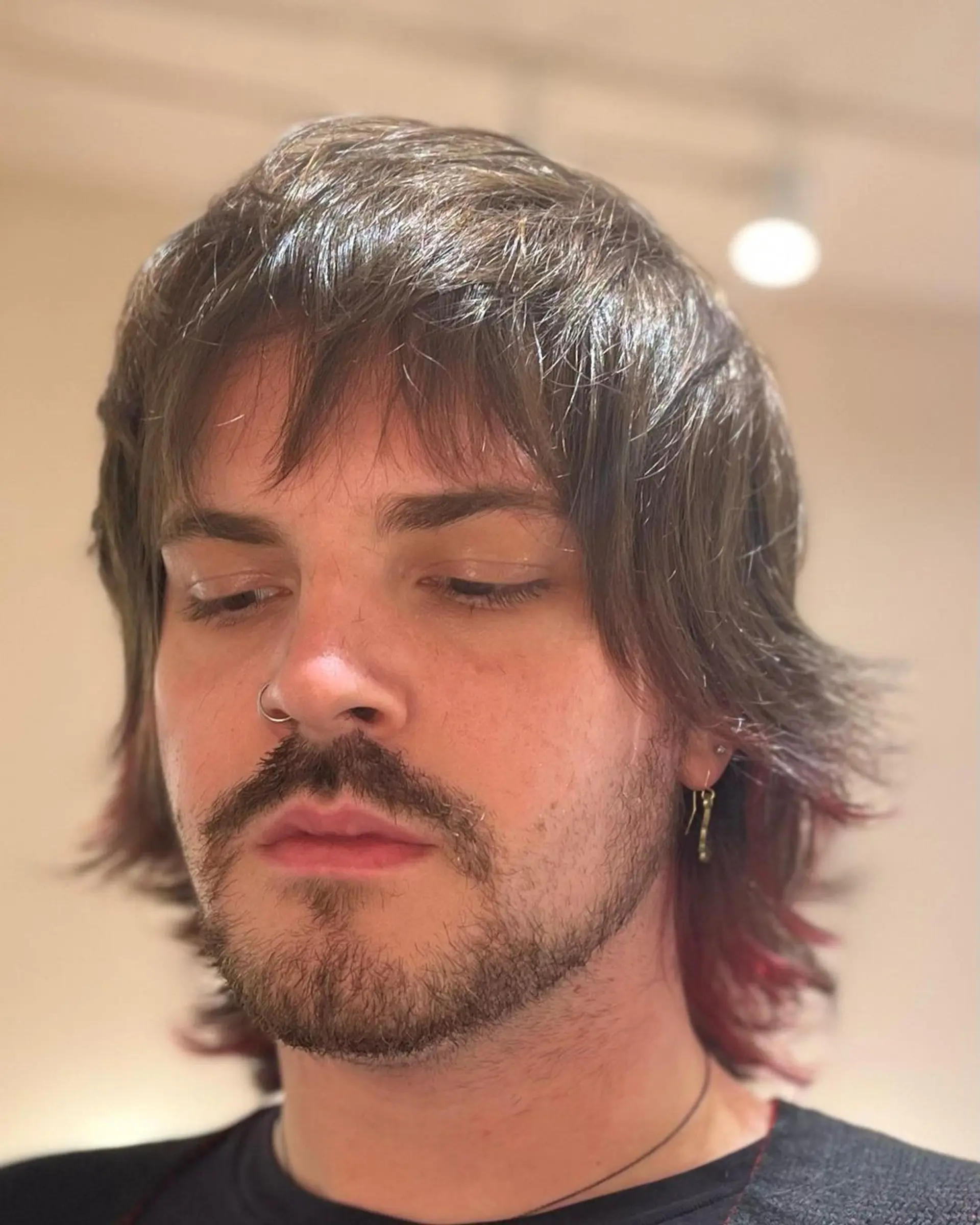 The hairstyle features medium-length straight hair with a natural brown base, accented by undercut pink highlights. Shaggy layers and feathered ends create an edgy look, complemented by a side-swept fringe. 4