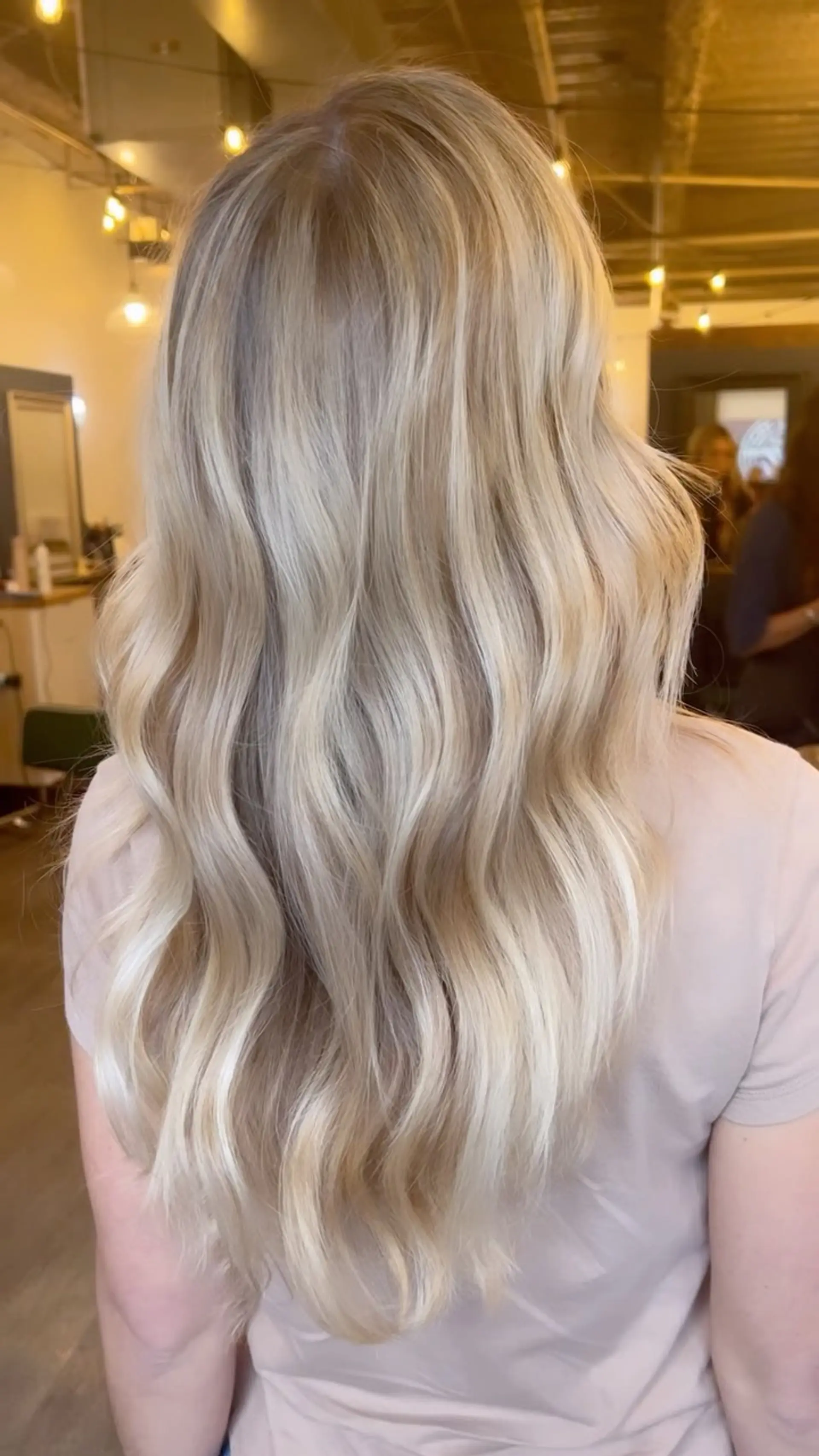 Long creamy blonde hair styled with loose, dimensional beach waves. 1