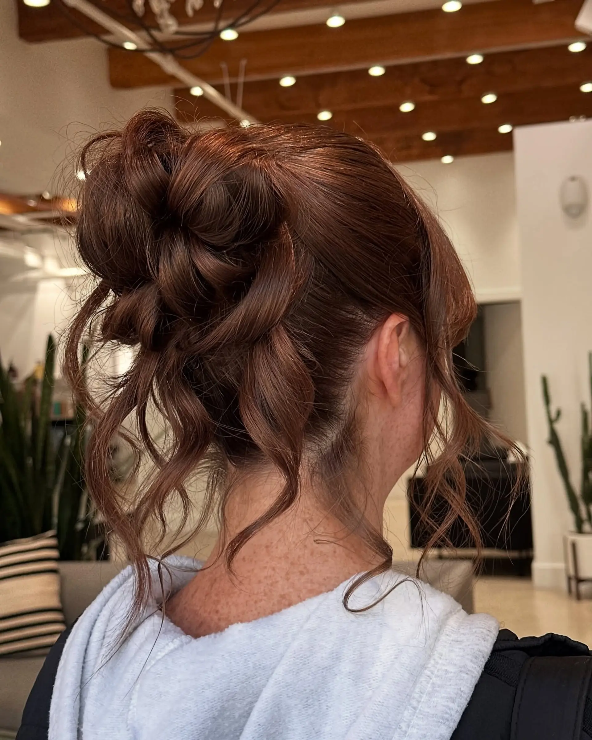 A beautifully twisted bun updo with wavy strands cascading down for a romantic touch. 1