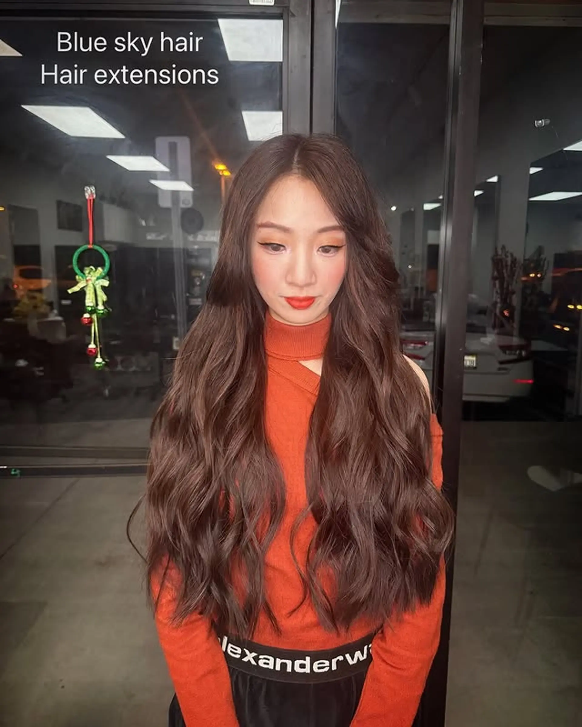 Long, flowing wavy hair with subtle caramel brown tones, achieved with the use of hair extensions. 1