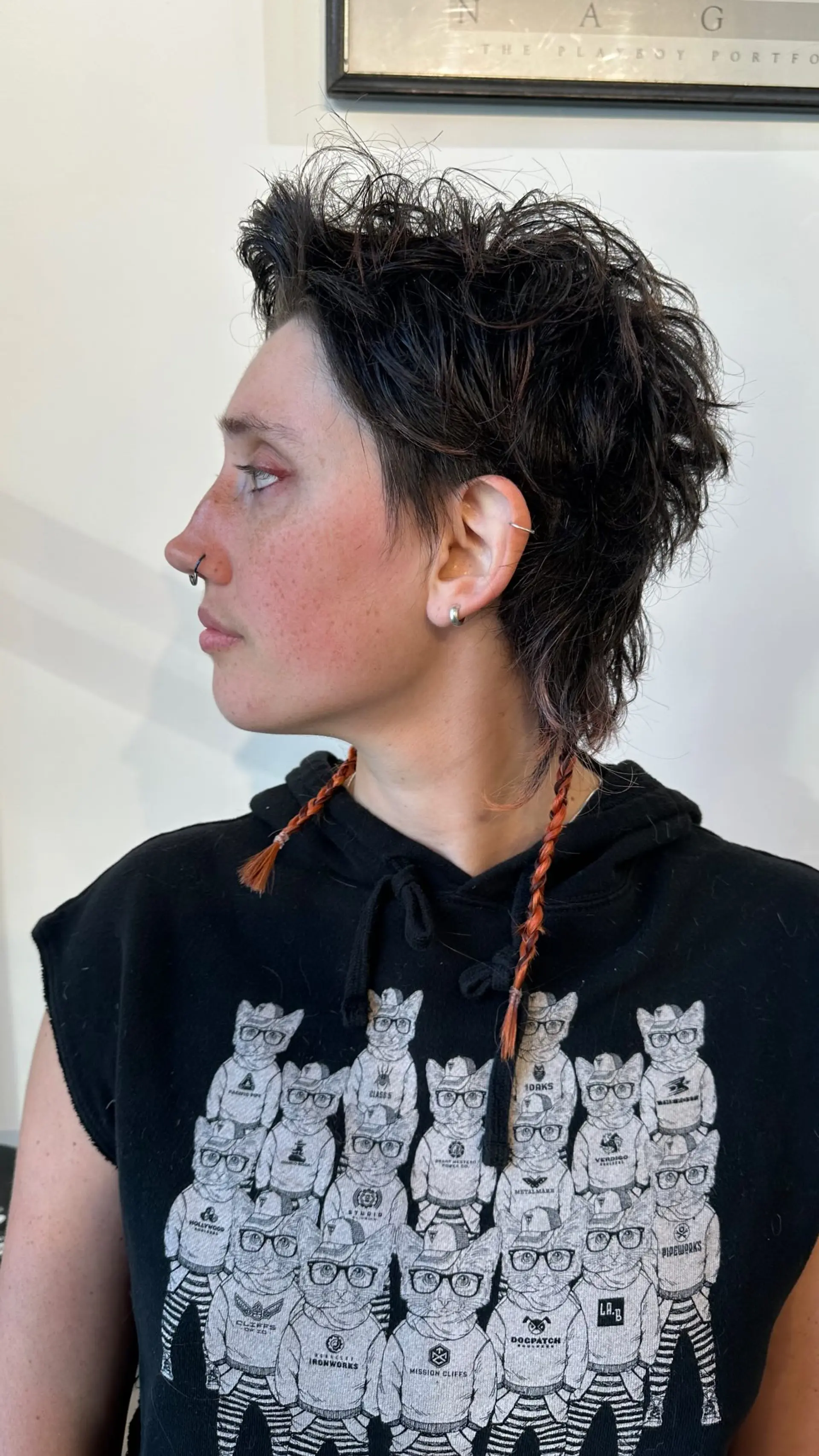 A razor-cut textured shaggy mullet styled with tousled, voluminous layers on top and two thin copper-toned accent braids falling in front of the shoulders. 1