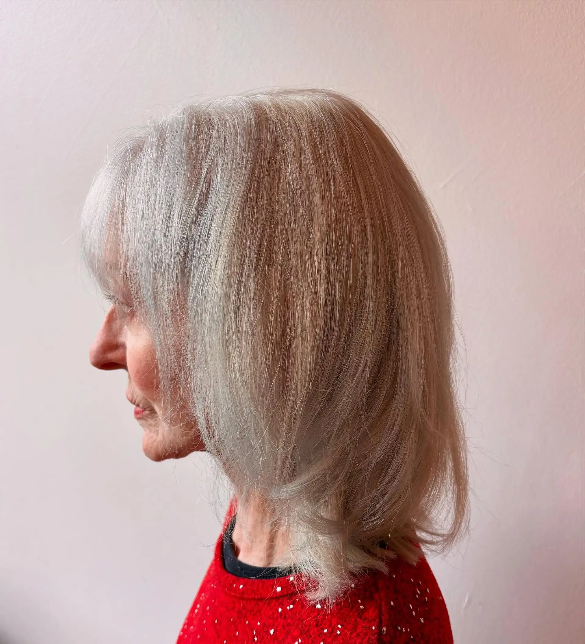 A shoulder-length platinum white blonde lob with soft wispy bangs and gentle inward-swept layers. 1