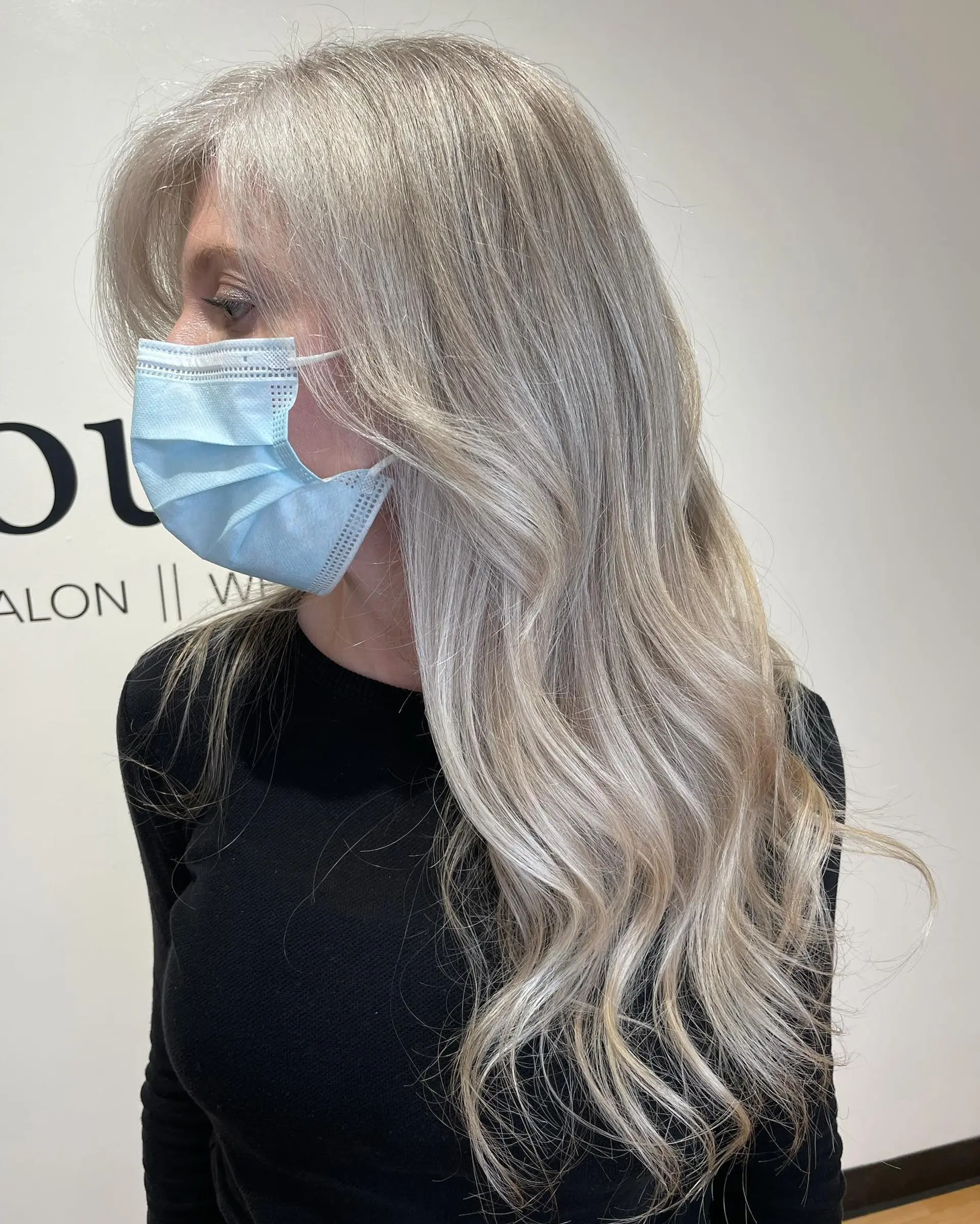 Long ash blonde and silver gray-blending highlights styled into soft, flowing waves. 1