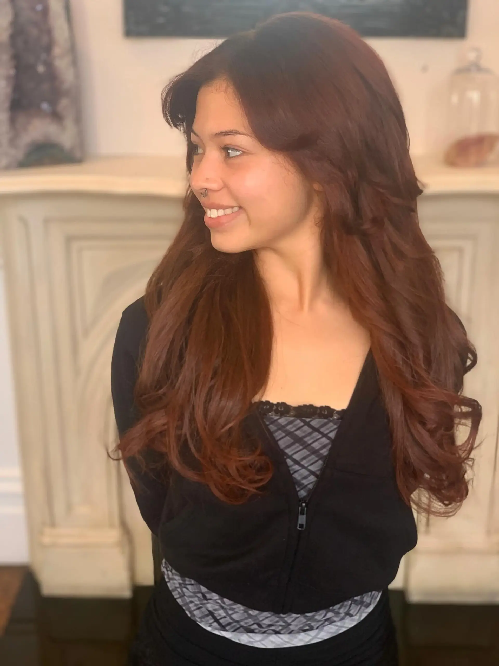 Rich auburn long hair cut with face-framing layers and styled in soft, bouncy waves. 1