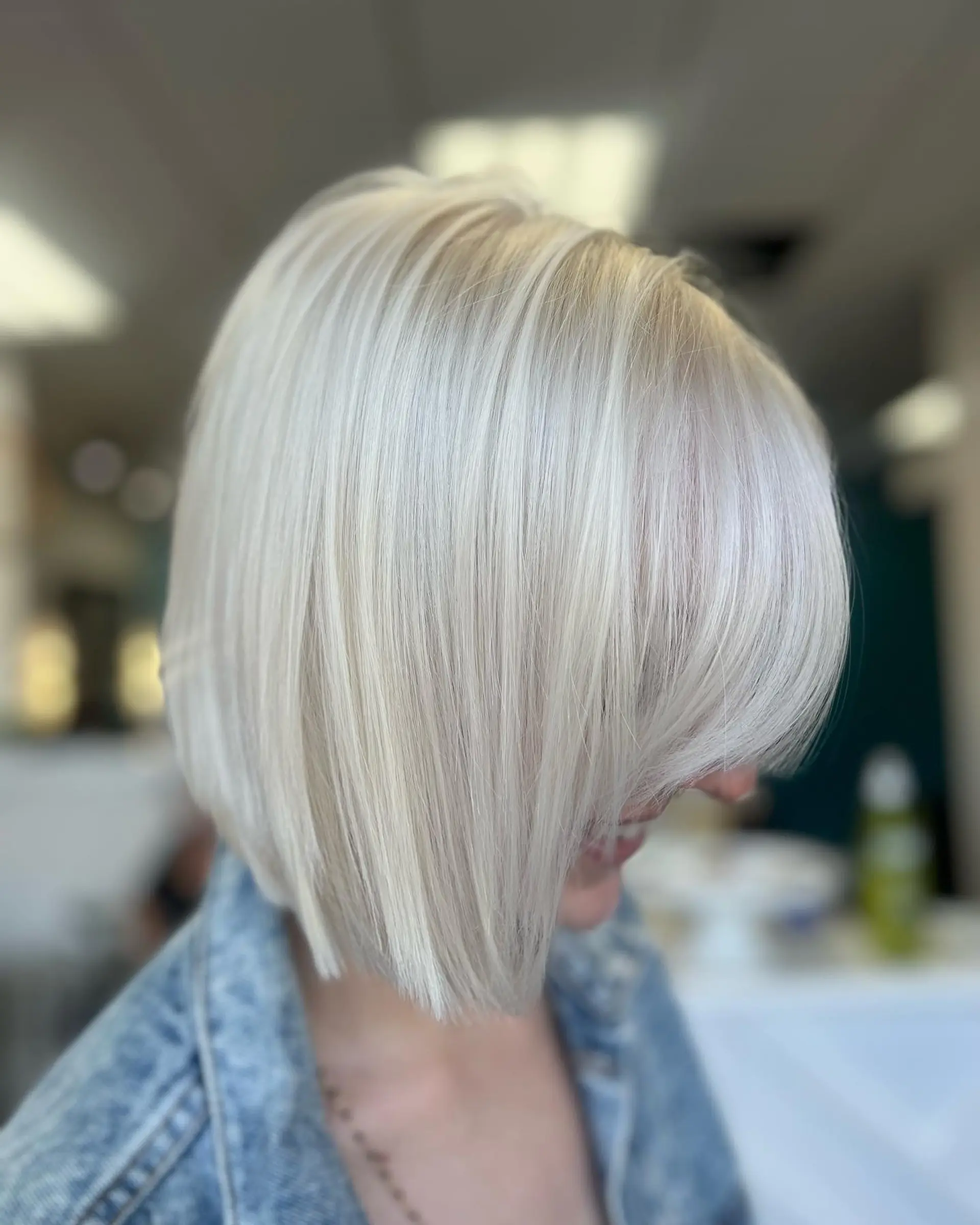 A sleek, straight platinum blonde bob with soft side-swept front layers. 1
