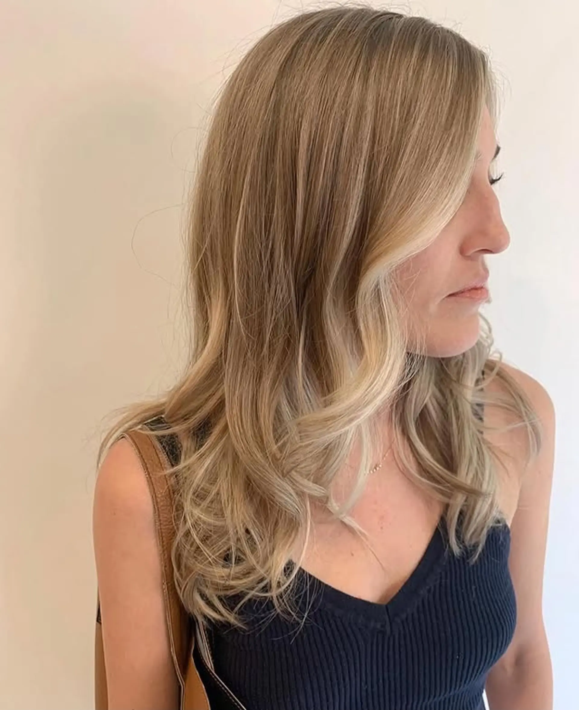 A medium-length wavy hairstyle with blonde balayage highlights. 1