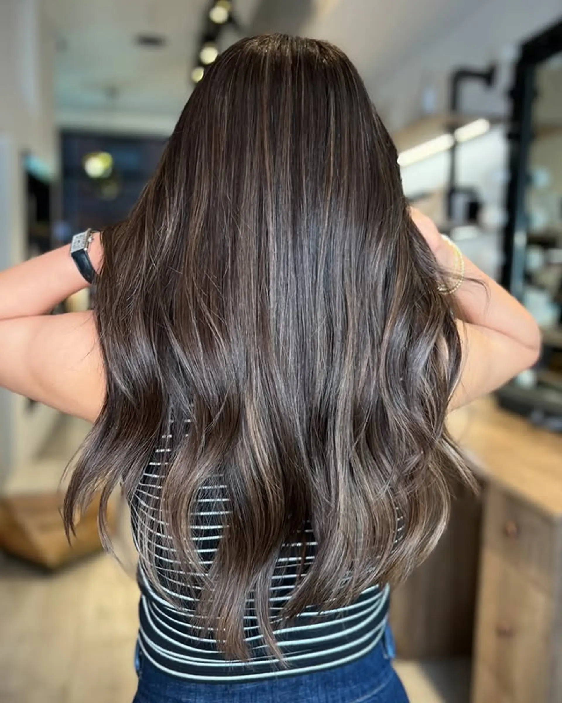 Long, wavy hair with a bronzed brunette balayage and rooted effect. 1