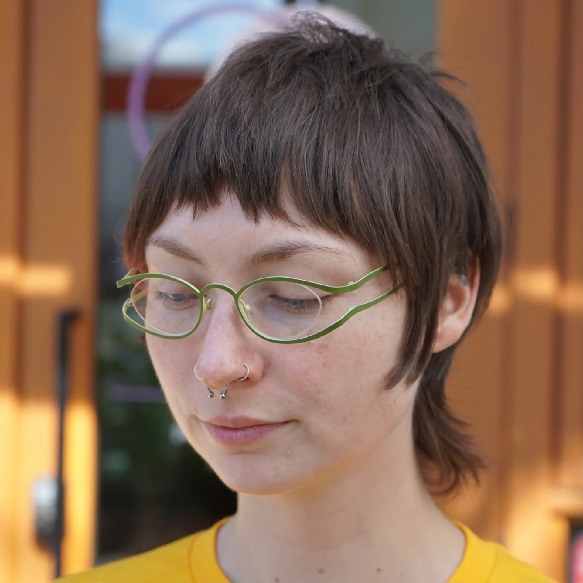 A textured mixie cut combining the cropped top of a pixie with the flared length of a mullet at the nape, paired with choppy baby bangs and soft framing along the sides. 1