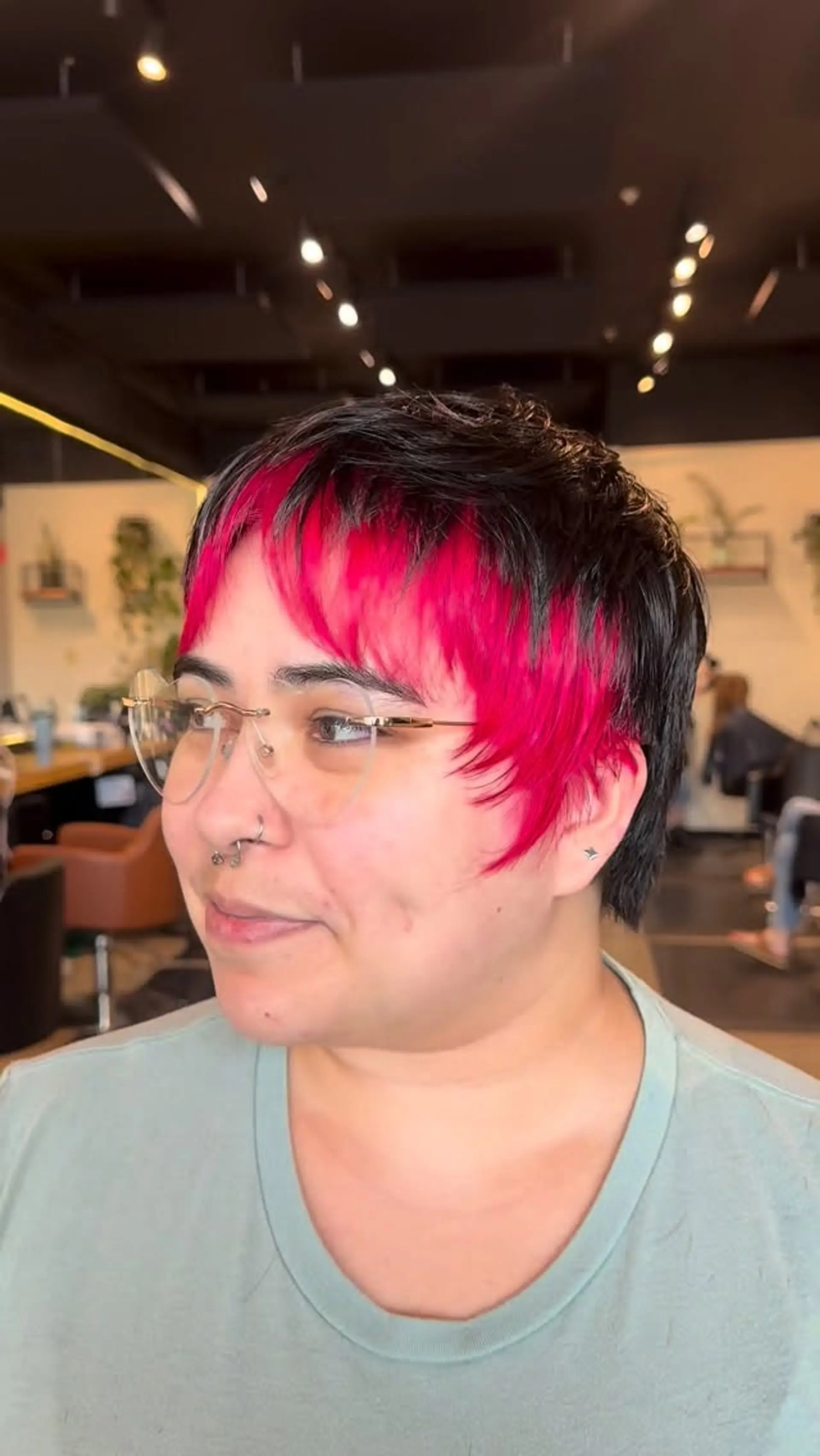 A short, piecey dark crop featuring a vibrant hot pink fringe and face-framing accent pieces. 1