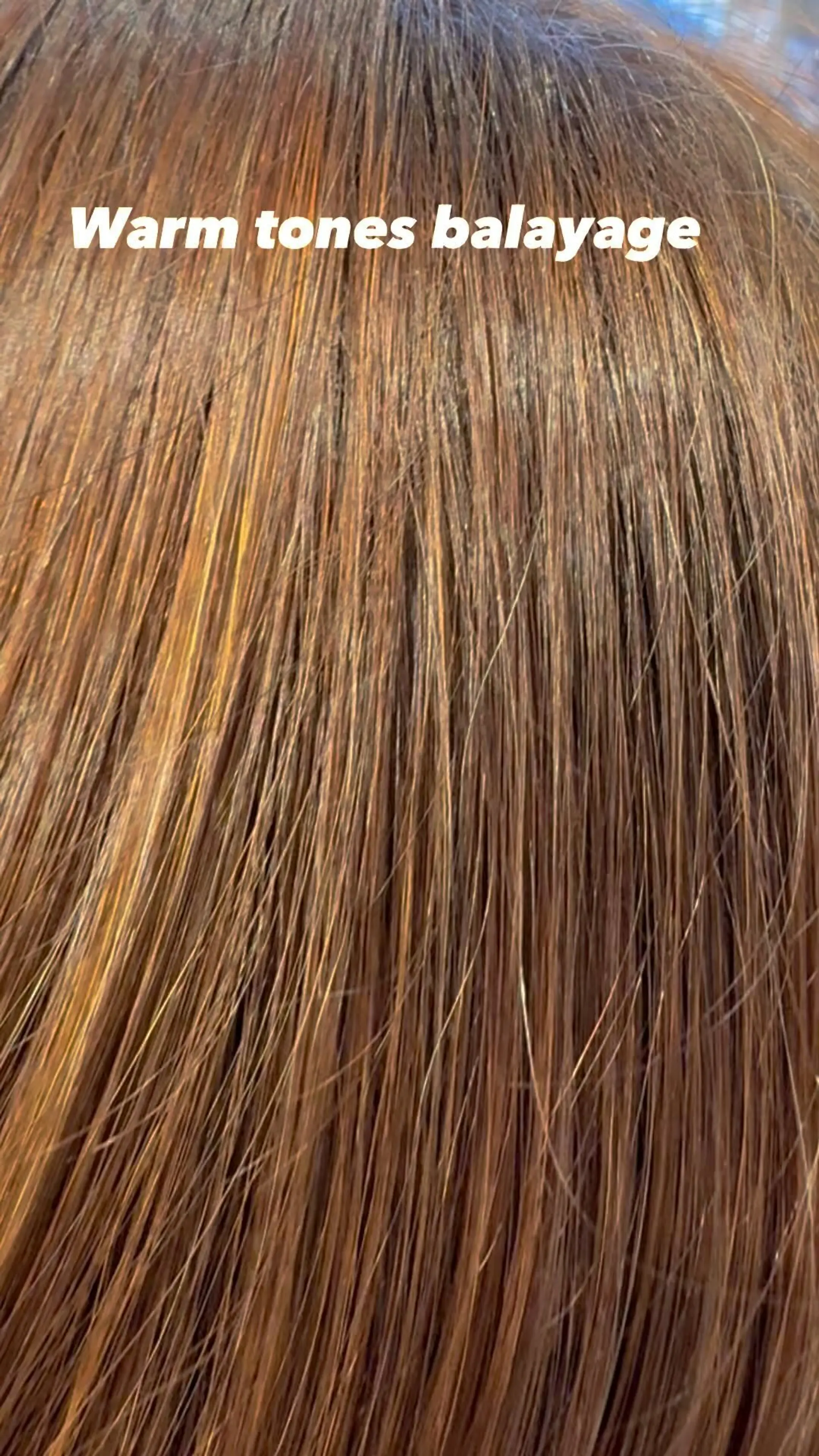 A close-up view of straight hair featuring warm-toned balayage highlights in rich copper and auburn hues. 1