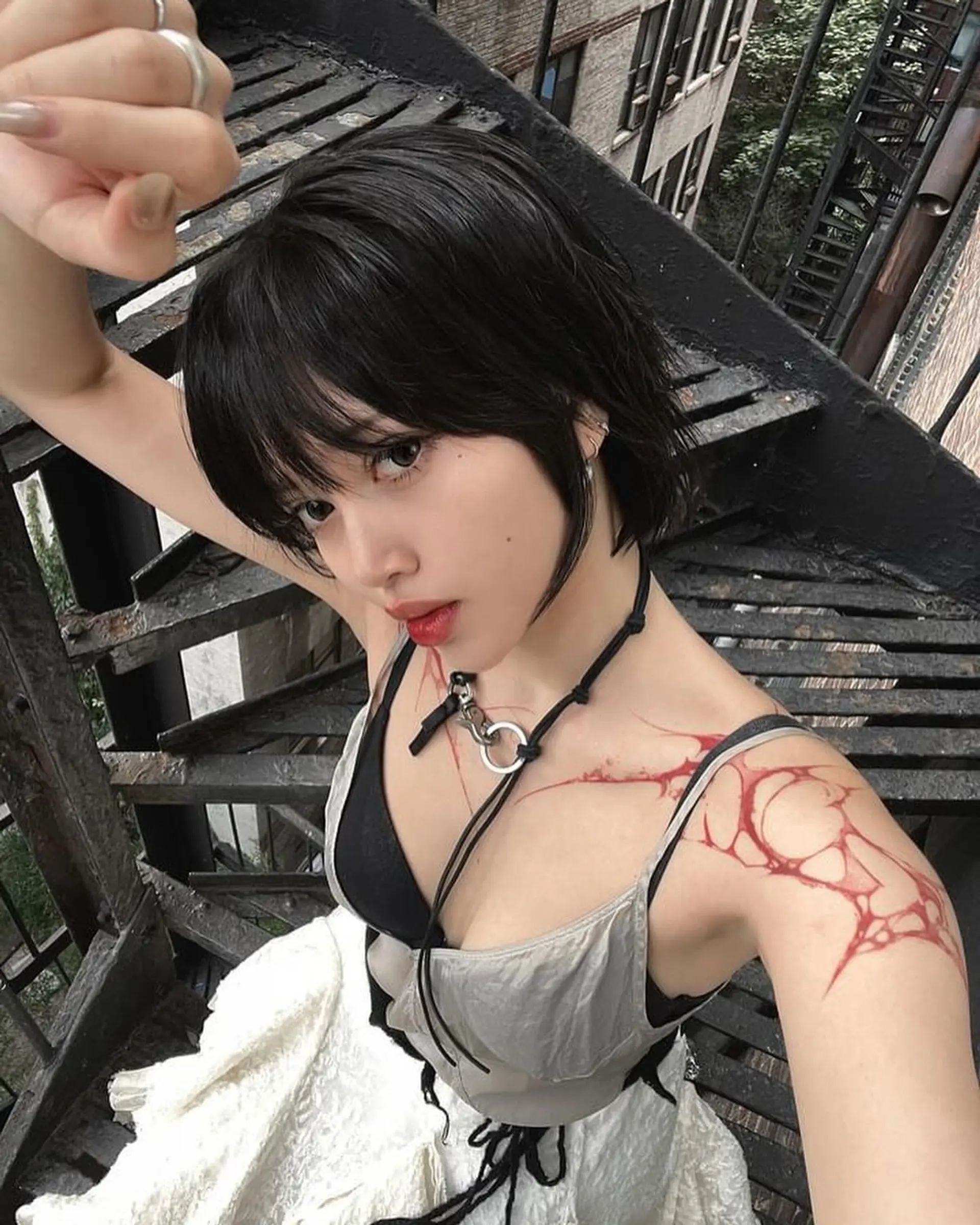 A short, wavy black hairstyle with choppy layers, textured ends, and a face-framing fringe for an edgy, urban chic look. 1