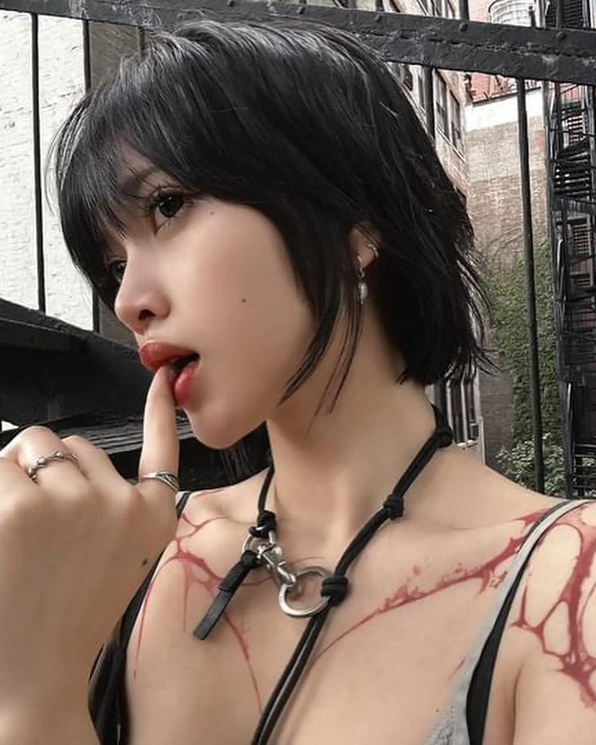 A short, wavy black hairstyle with choppy layers, textured ends, and a face-framing fringe for an edgy, urban chic look. 2
