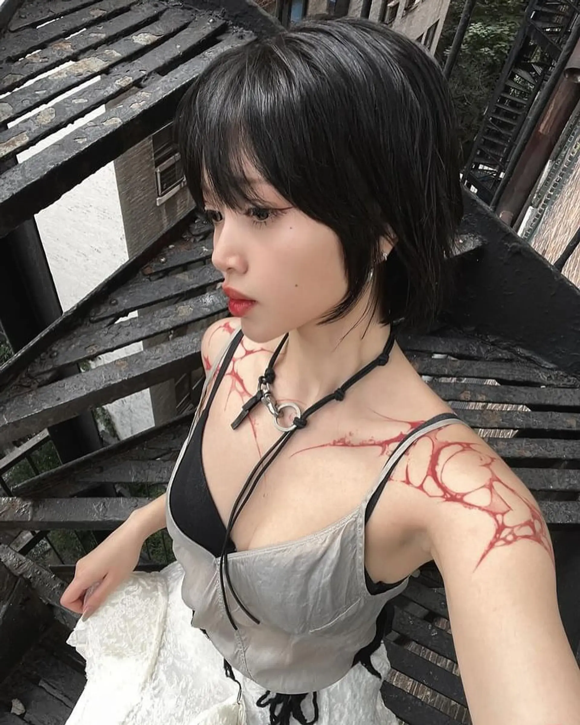 A short, wavy black hairstyle with choppy layers, textured ends, and a face-framing fringe for an edgy, urban chic look. 3