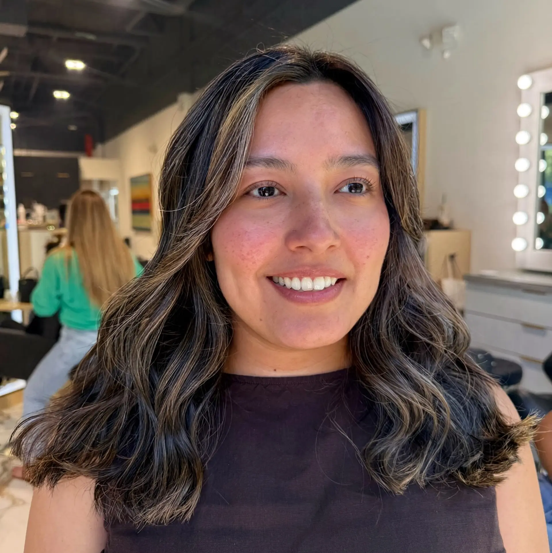 Shoulder-length brunette hair styled in loose waves with fine, dimensional babylights throughout. 1