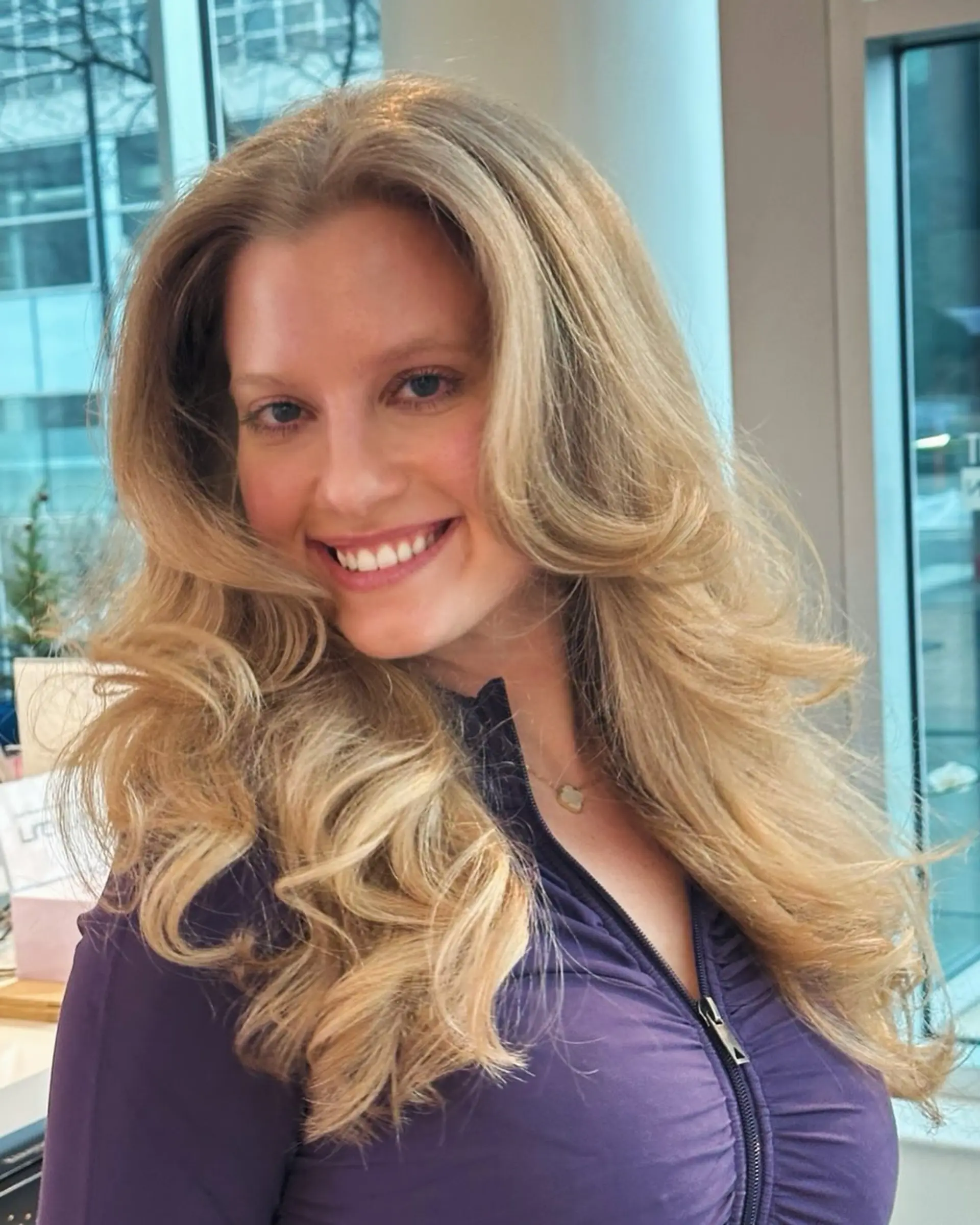 A layered haircut with soft waves and face-framing layers for added volume. 1