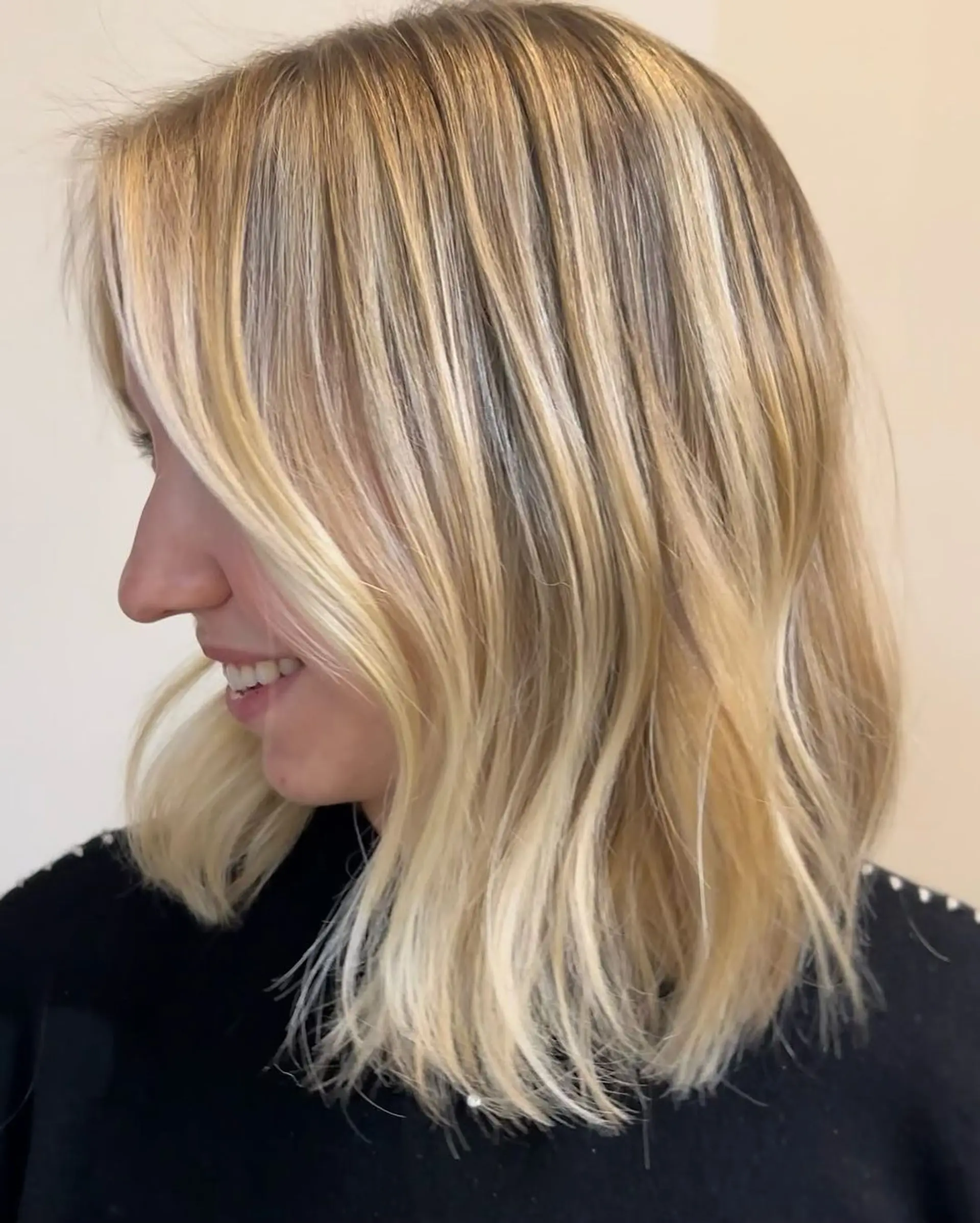 Medium-length wavy hair with sunlit balayage highlights and face-framing layers, creating a soft and radiant look. 3