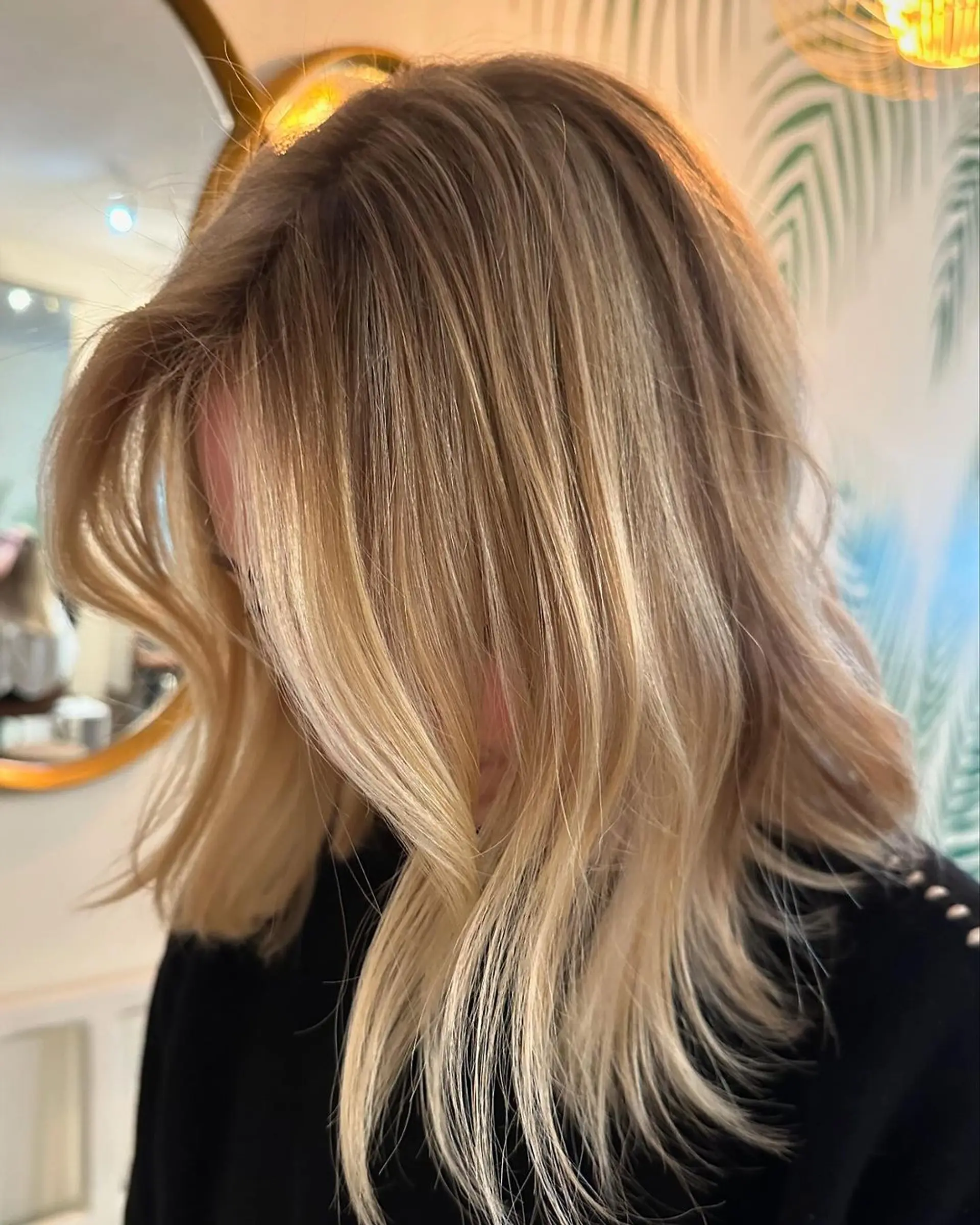 Medium-length wavy hair with sunlit balayage highlights and face-framing layers, creating a soft and radiant look. 1