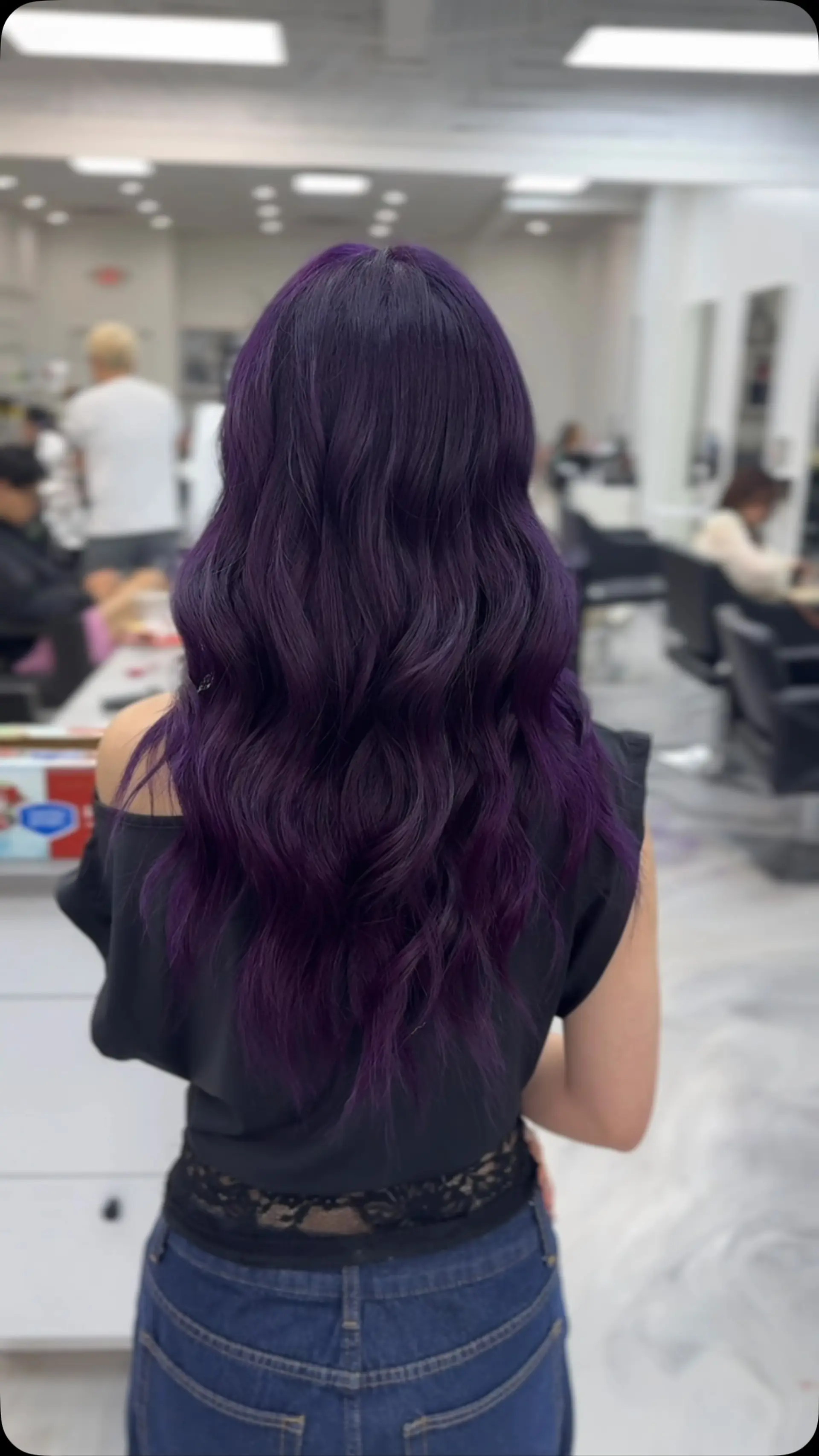 Long deep purple hair styled into smooth, textured waves cascading down the back. 1