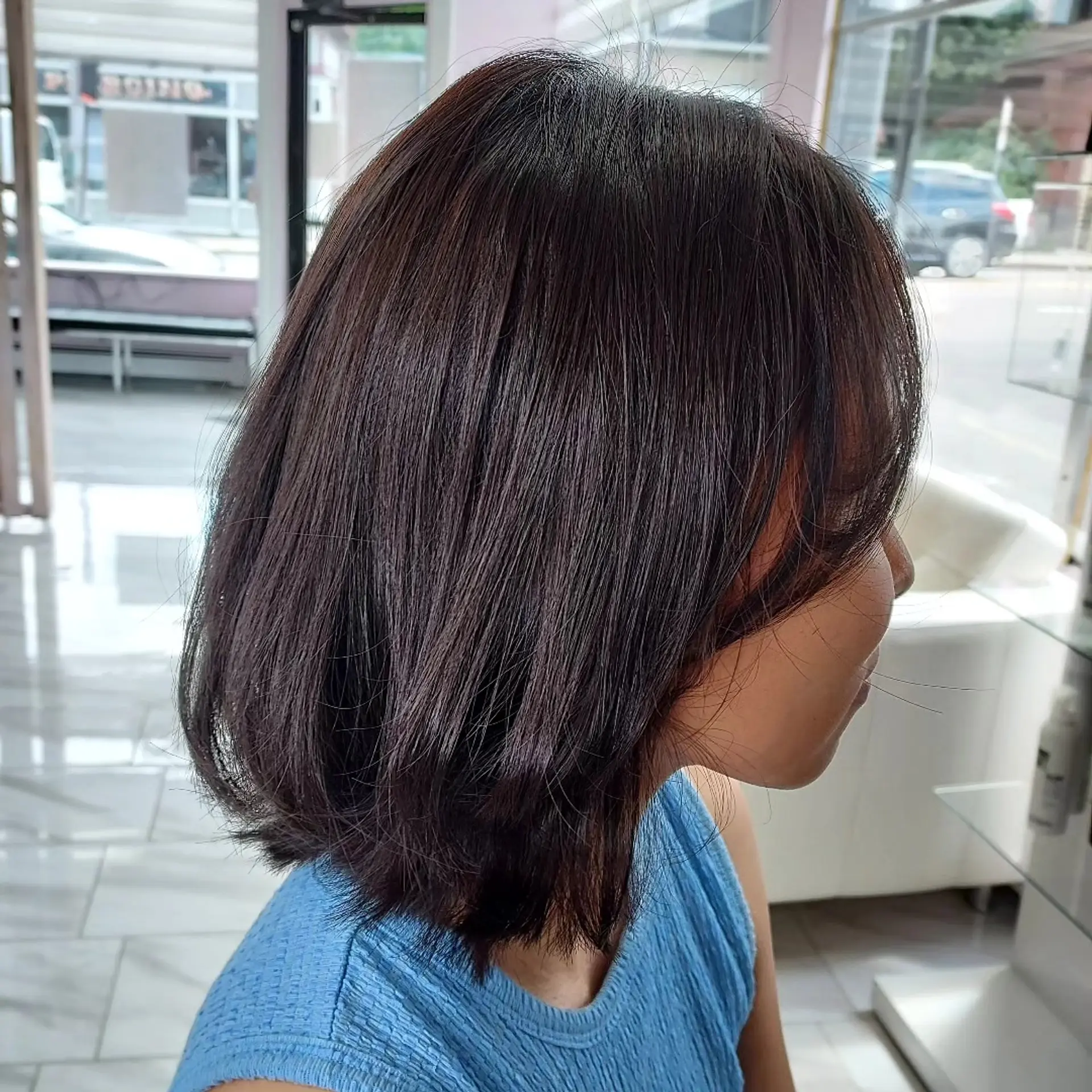 A textured shoulder-skimming dark brown bob haircut styled with subtle layers and soft face-framing fringe. 1