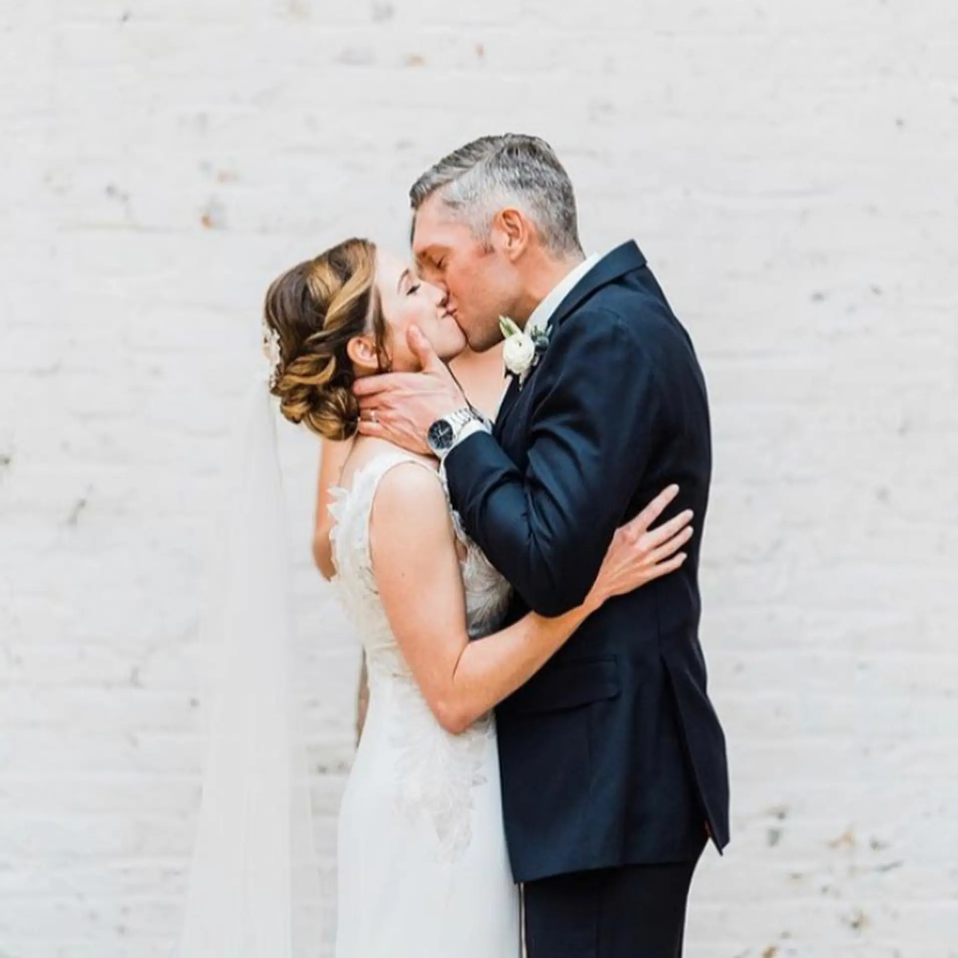 A romantic bridal updo styled into an elegant textured low bun with dimensional highlights. 1